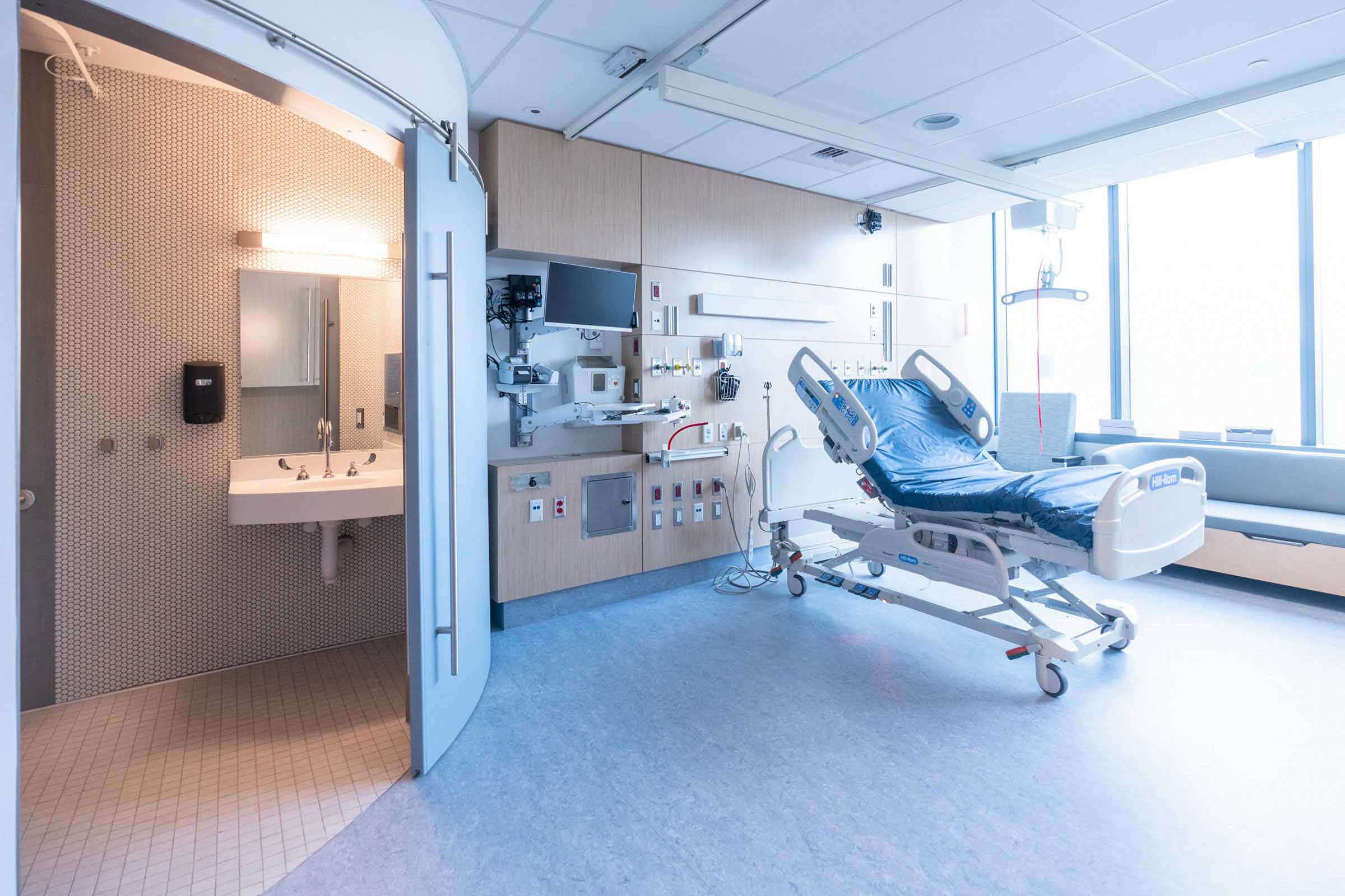 Hospital Room with the bathroom on the left and a hospital bed on the right