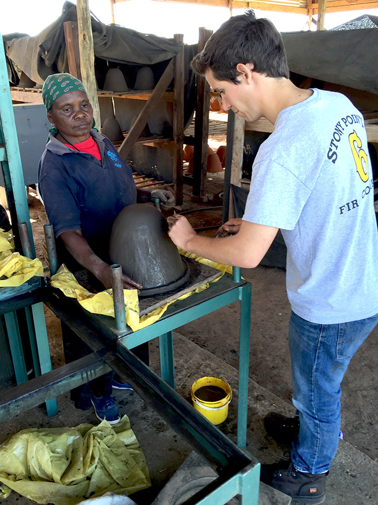 J.C. Panagides, a rising third-year biomedical engineering student who serves as the PureMadi team leader this summer, discusses filter-making with Sara, a worker with a pottery cooperative in South Africa.