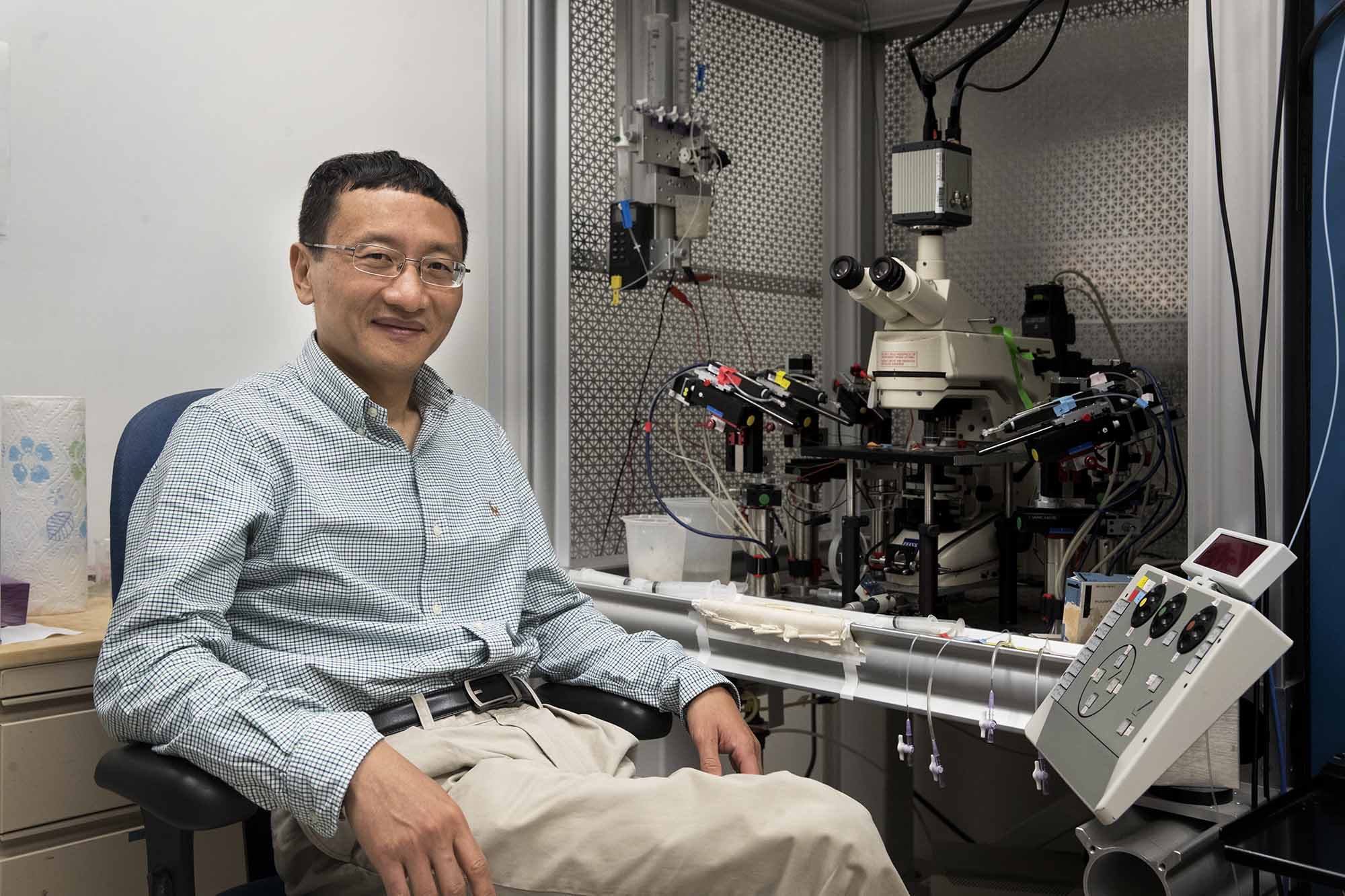 J. Julius Zhu sits in a chair in the lab