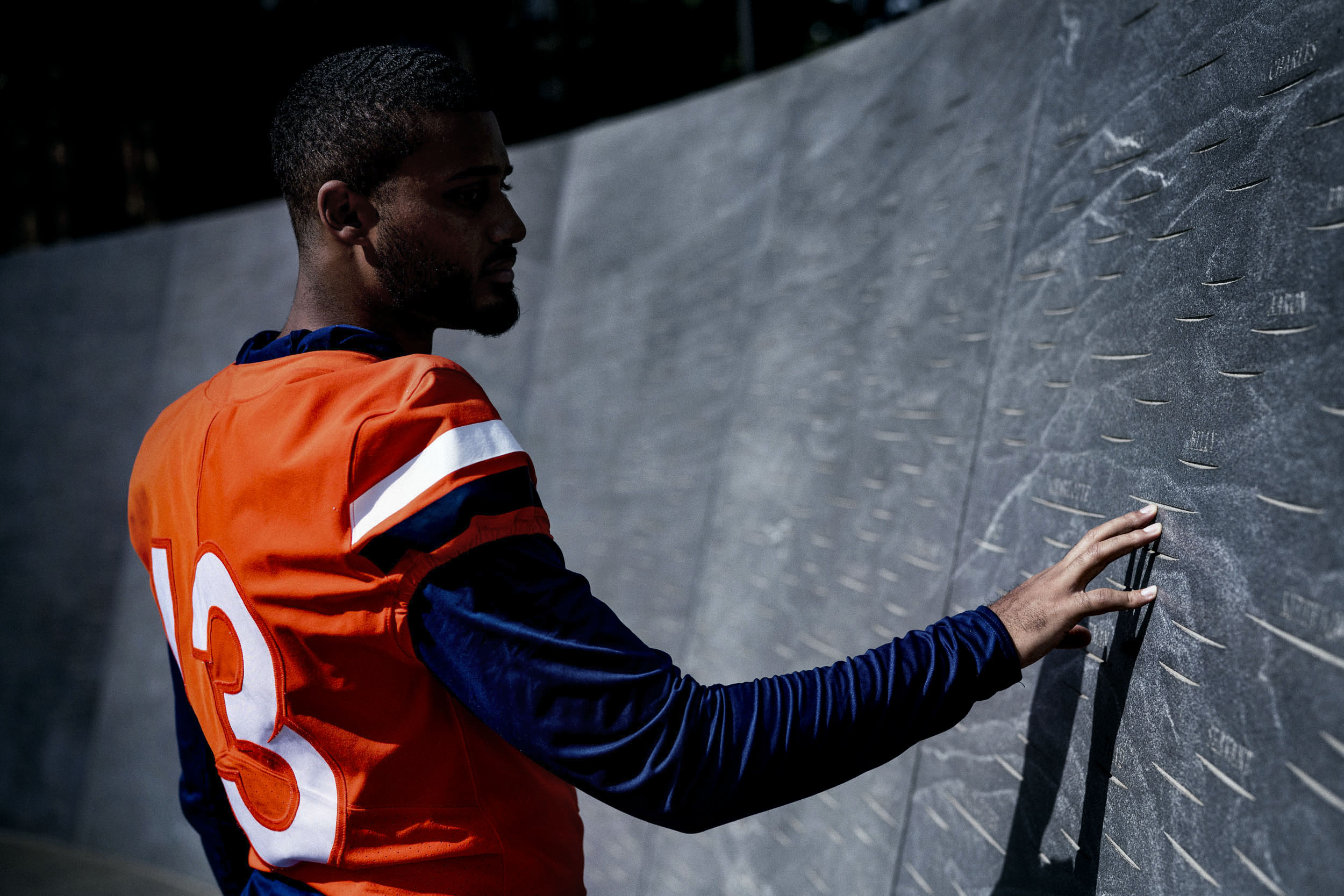 Terrell Jana touches the Memorial of Enslaved Laborers