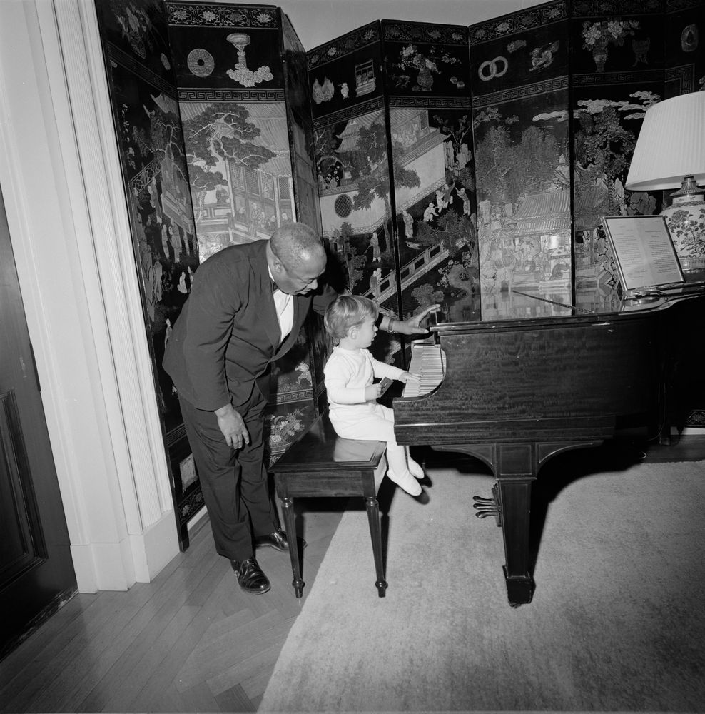 Black and white image of Thomas with John F. Kennedy Jr. playing the piano