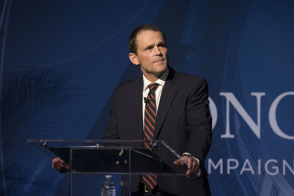 Jim Ryan standing a podium giving a speech