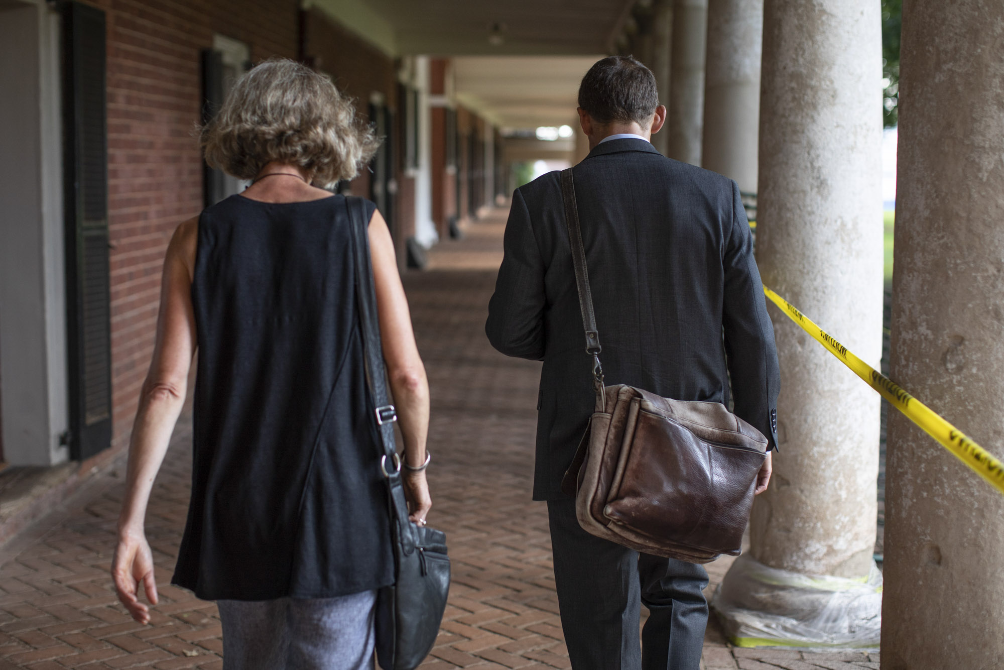 President Jim Ryan and his wife walk down the sidewalk on the Lawn