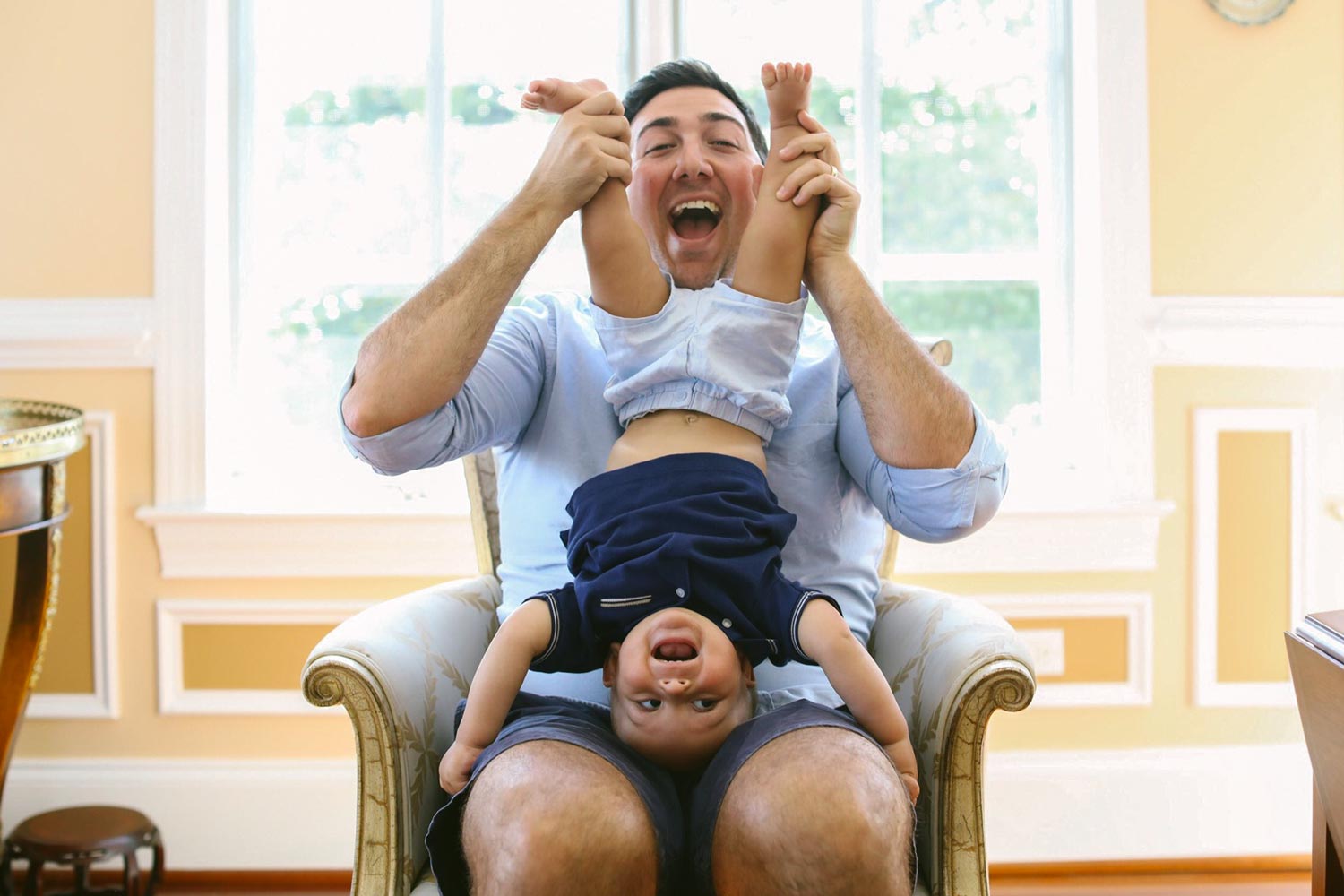 Katona holds his son Calvin upside down on his lap