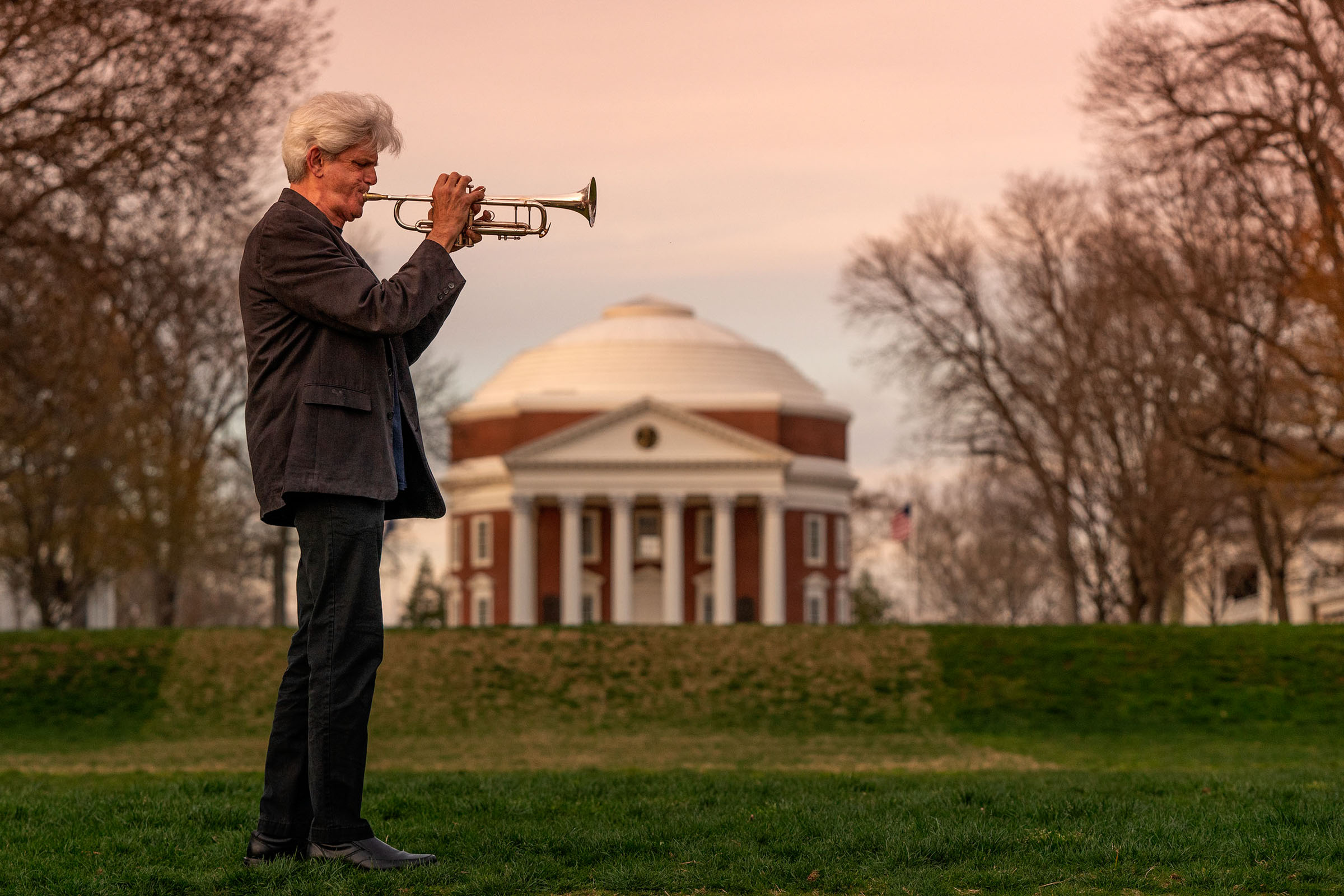 John Dearth facing right in the image plays his trumpet in front of the Rotunda