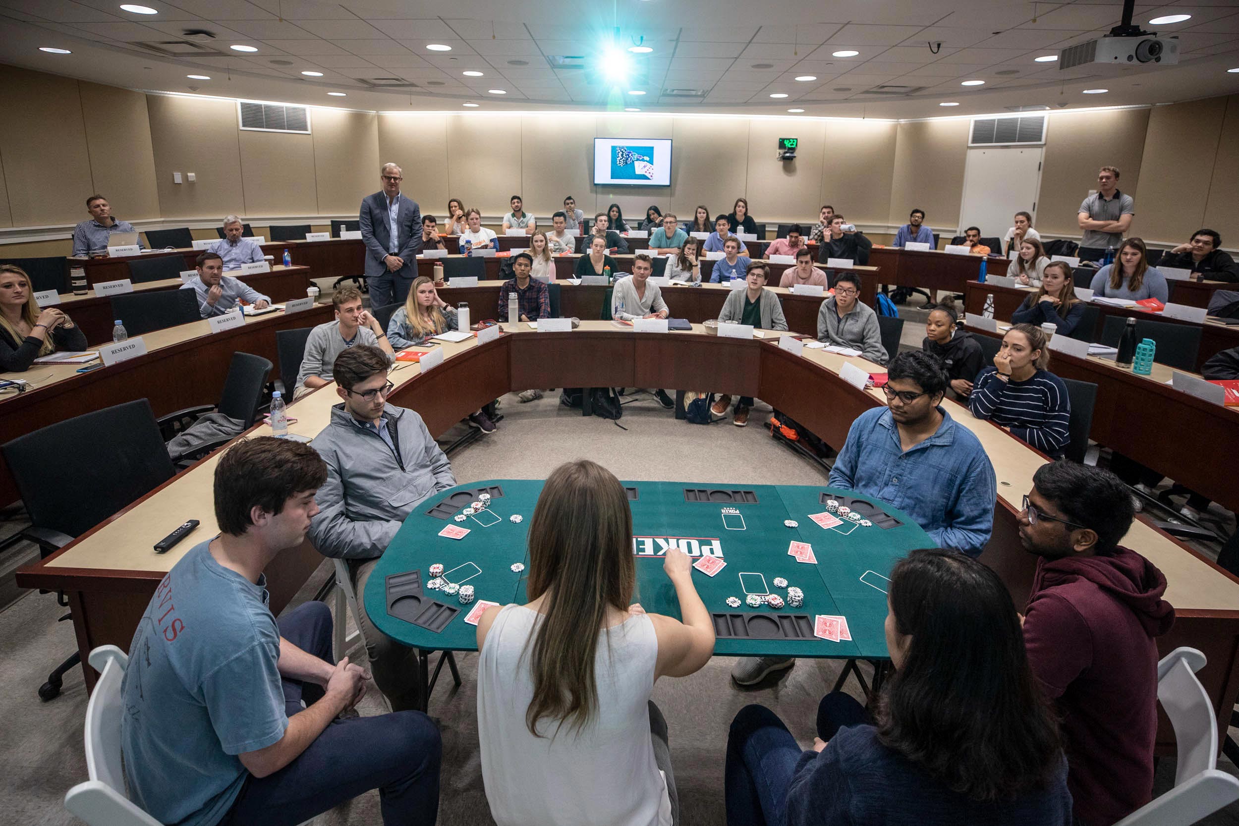 Konnikova sits at a poker table with 5 students to teach them a few tricks of poker