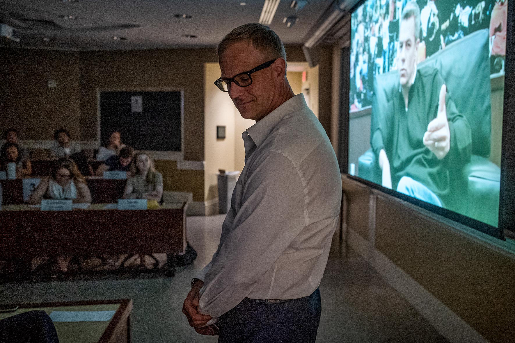 John Griffen stands to the side of his classroom as a video of Tony Bennett plays