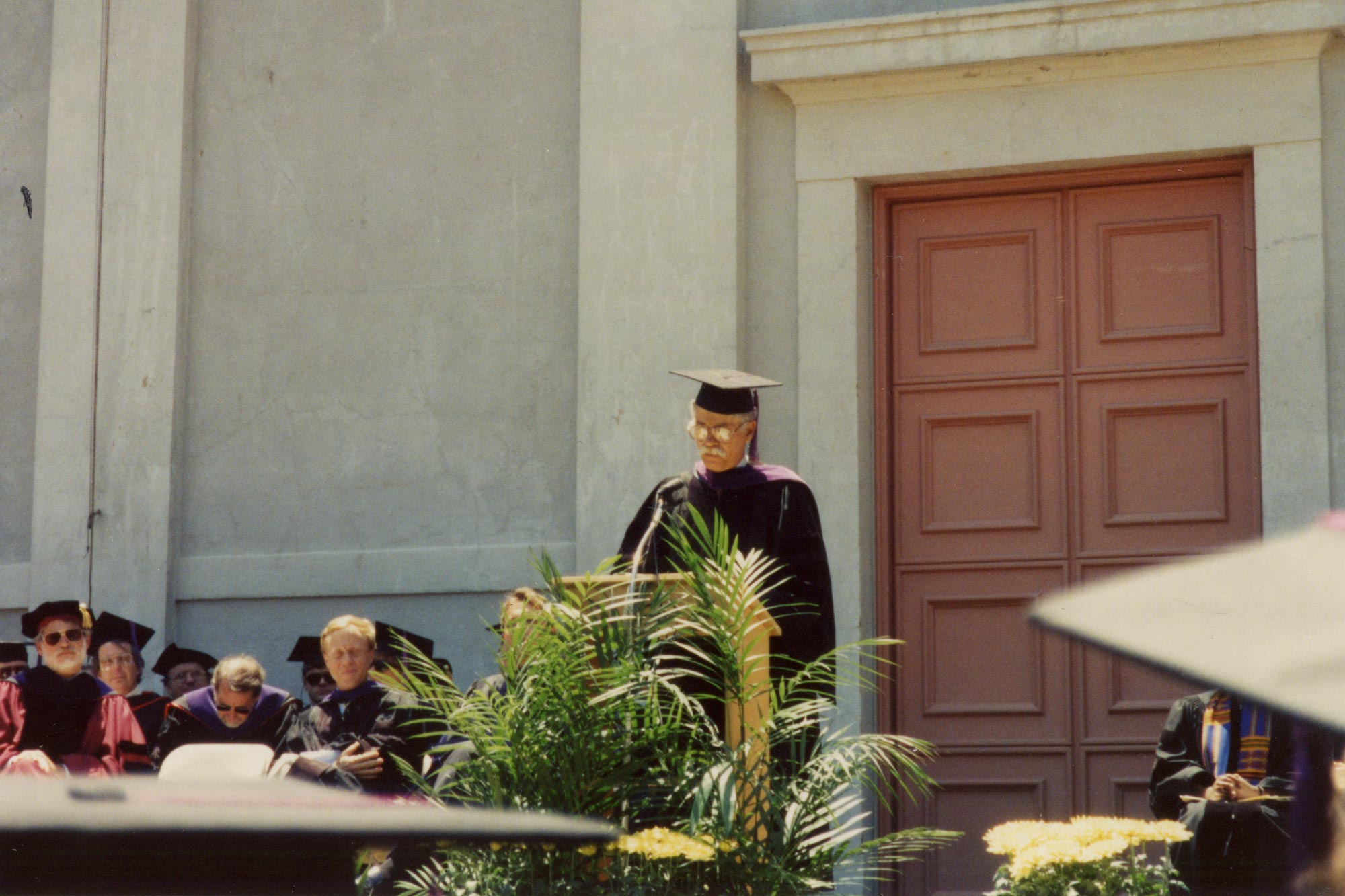Merchant standing at the podium at graduation giving a speech