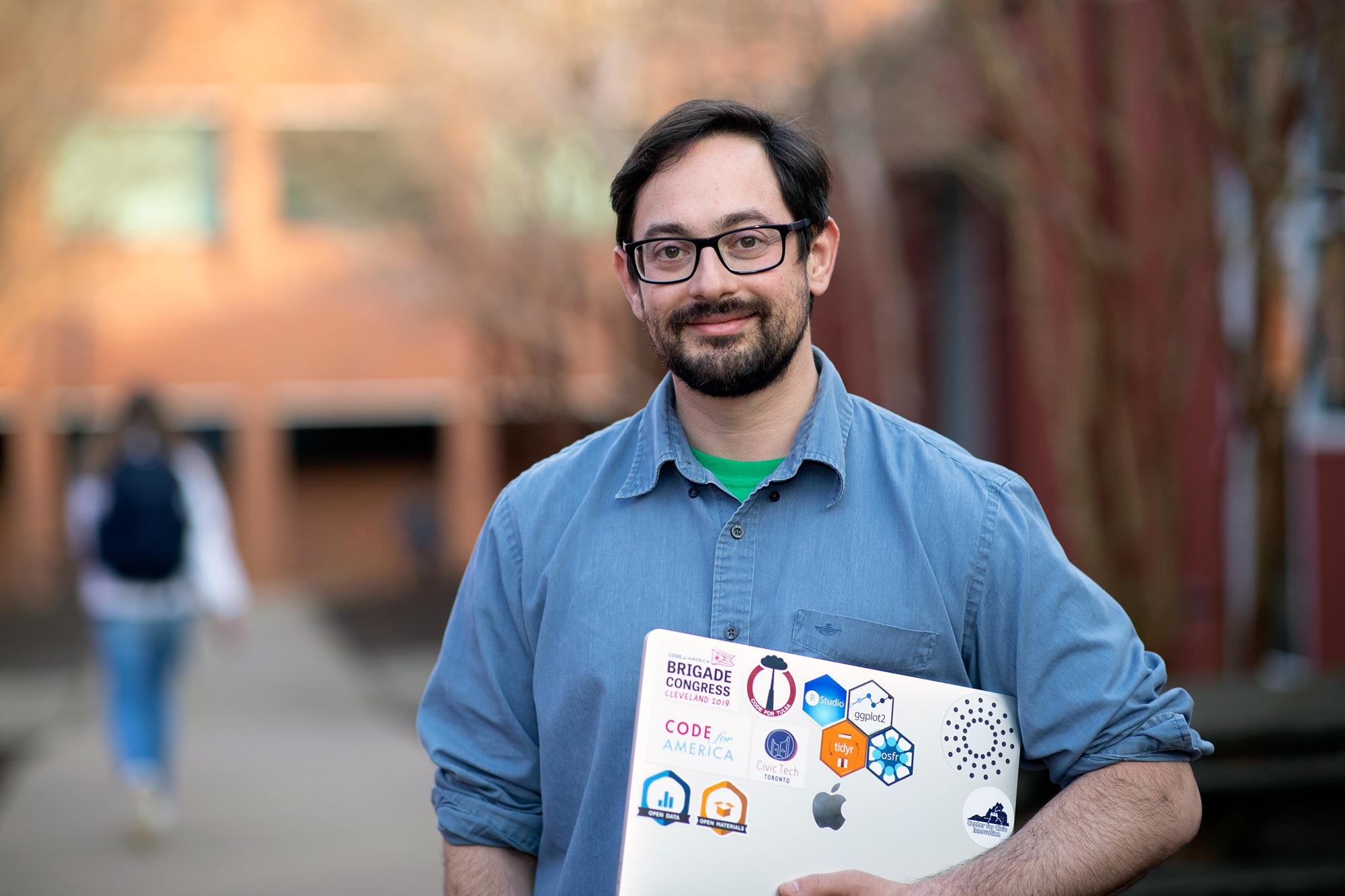 Kropko standing holding laptop smiling at camera