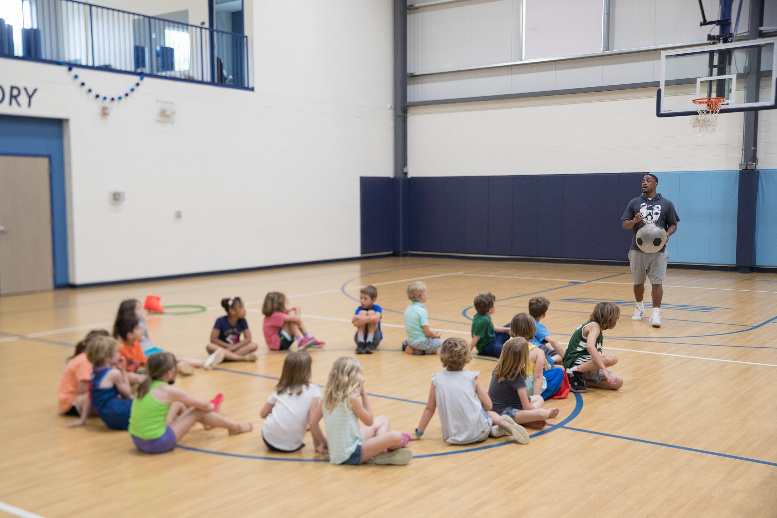 Jontel Evans talking to children on a basketball court