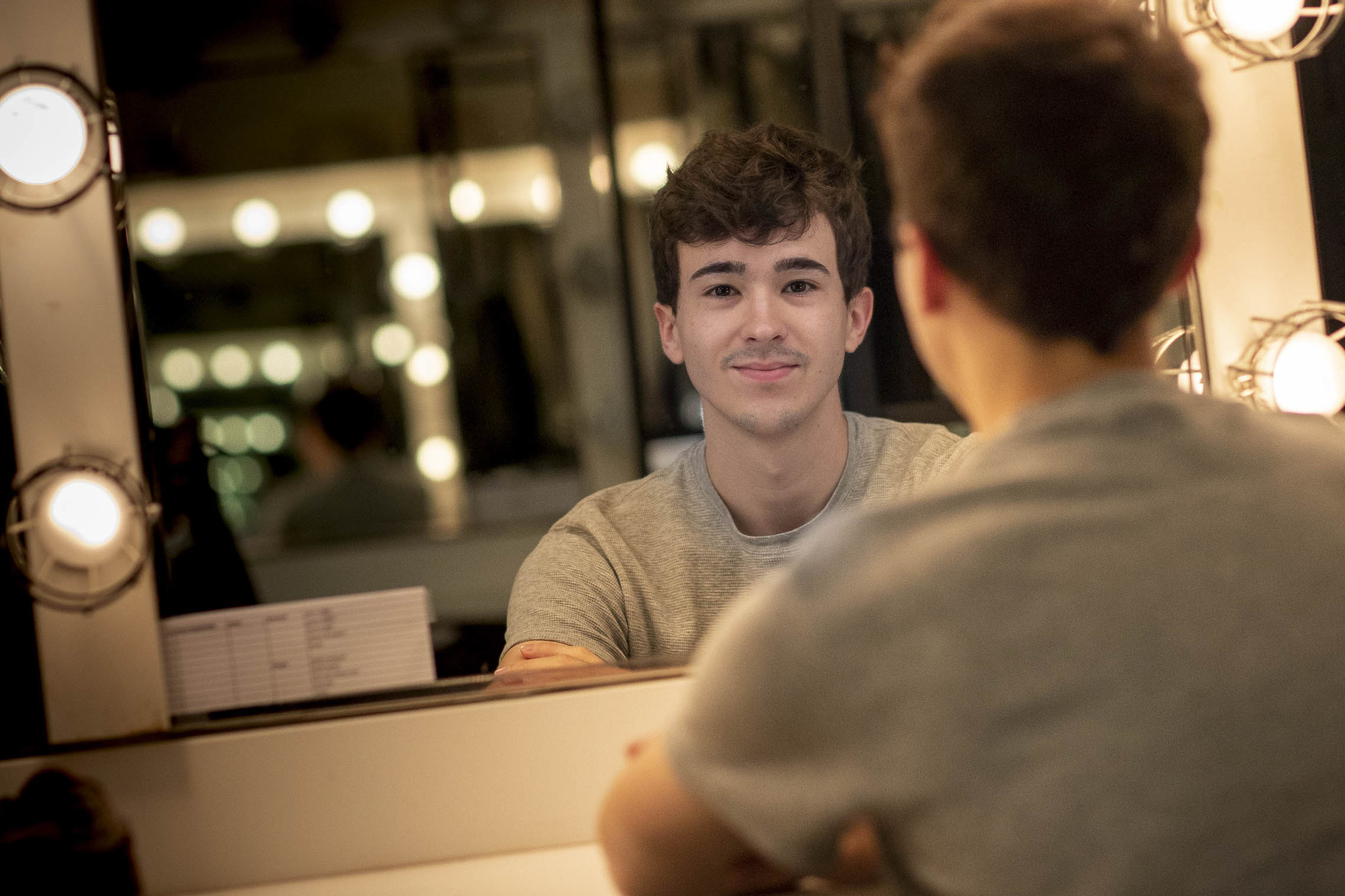 Julian Sanchez looks at the camera from a mirror backstage