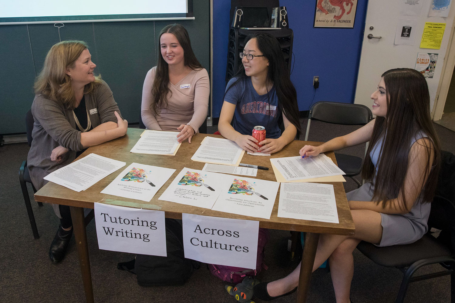 Kate Kostelnik, left, sits at a table with college students talking