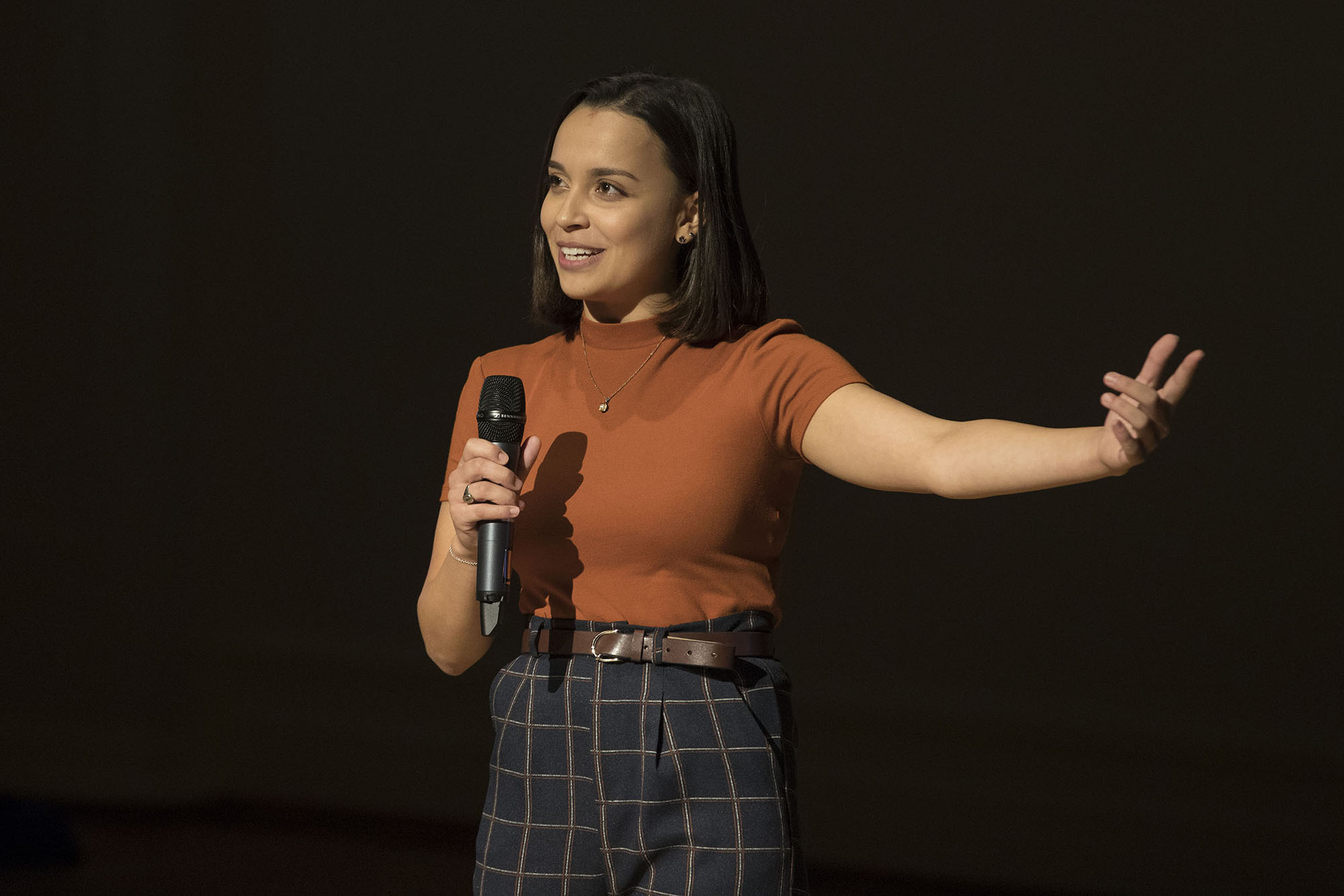 Kayla Dunn stand on stage talking into a microphone