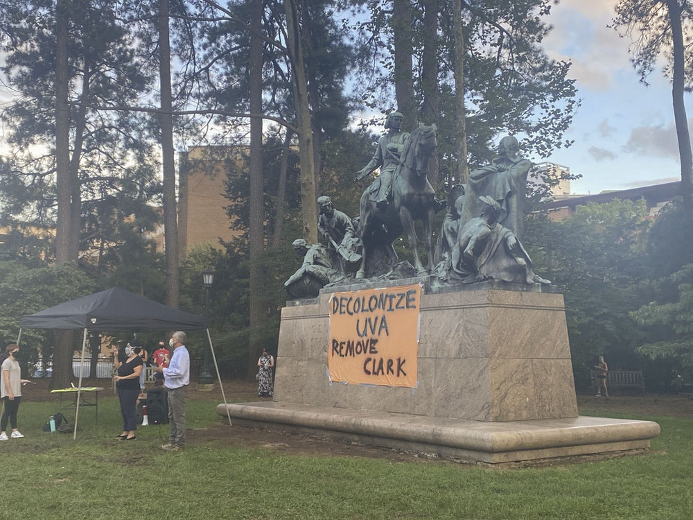 Clark statue with a homemade sign placed on the side of the monument that reads,  decolonize UVA remove clark