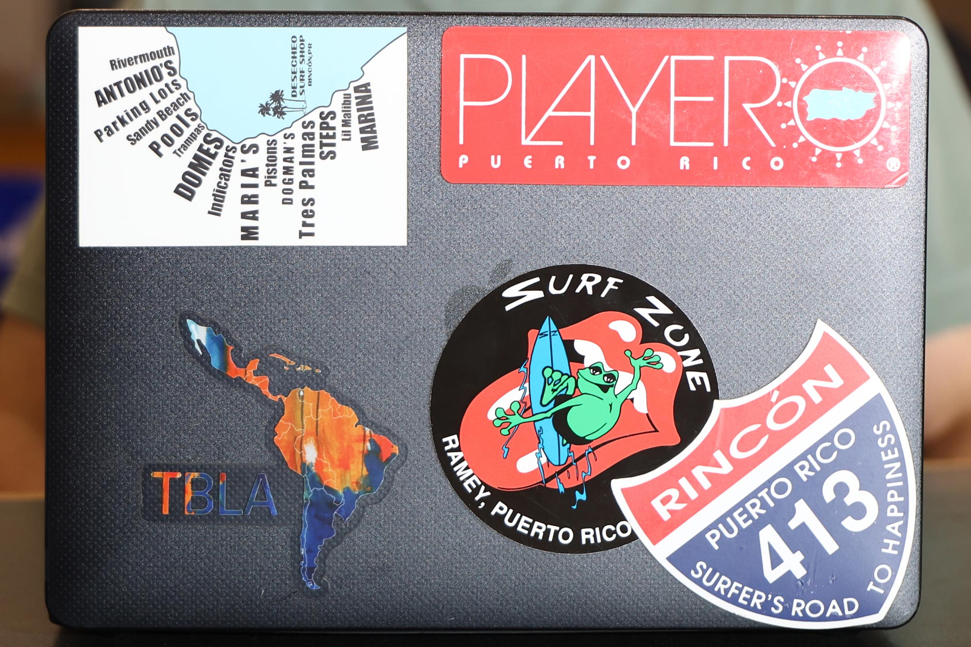 Lucas Radoncic displays his laptop lid showing stickers from his native country Puerto Rico all about surfing.
