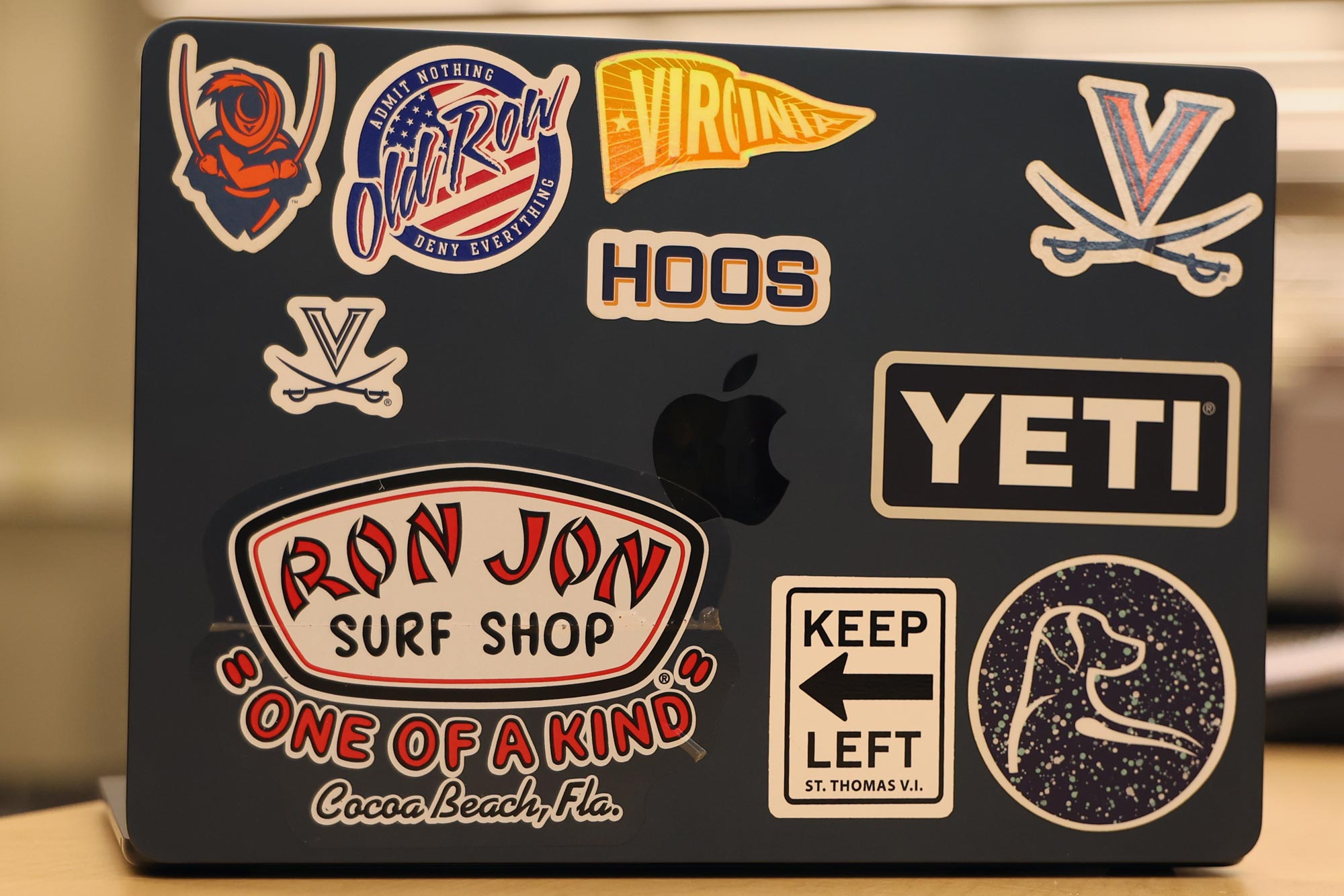 Ryan Weiner's laptop covered in UVA stickers and a surf shop sticker.