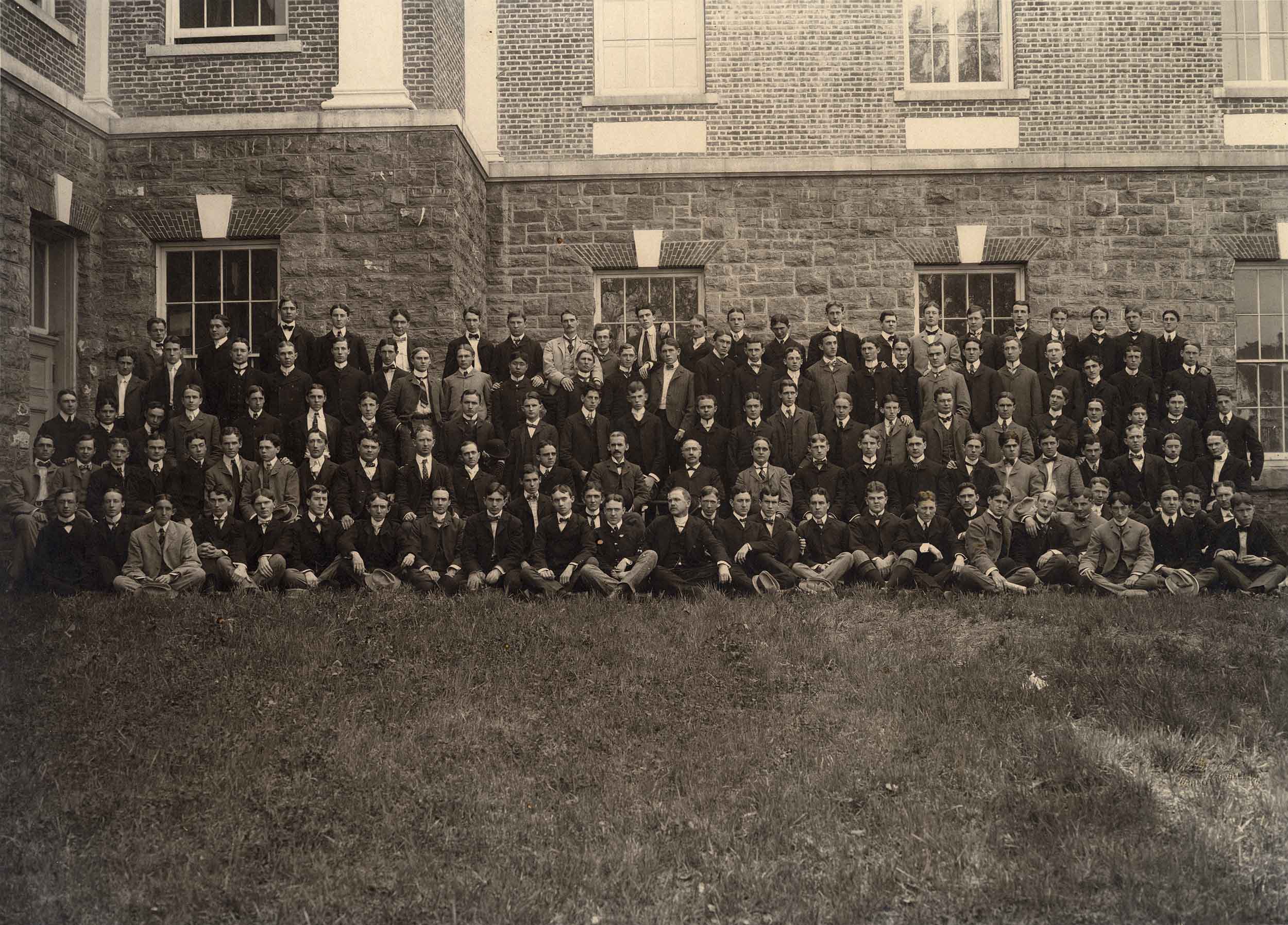black and white photo of men standing in rows for group pictures