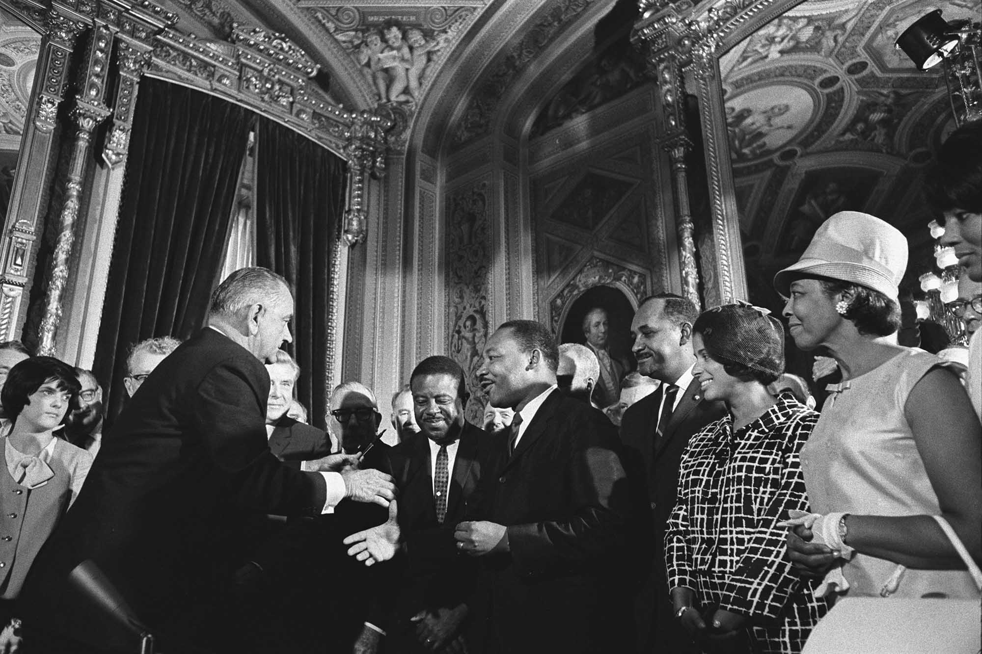 Martin Luther King J. meeting with Lyndon B. Johnson with crowd of people