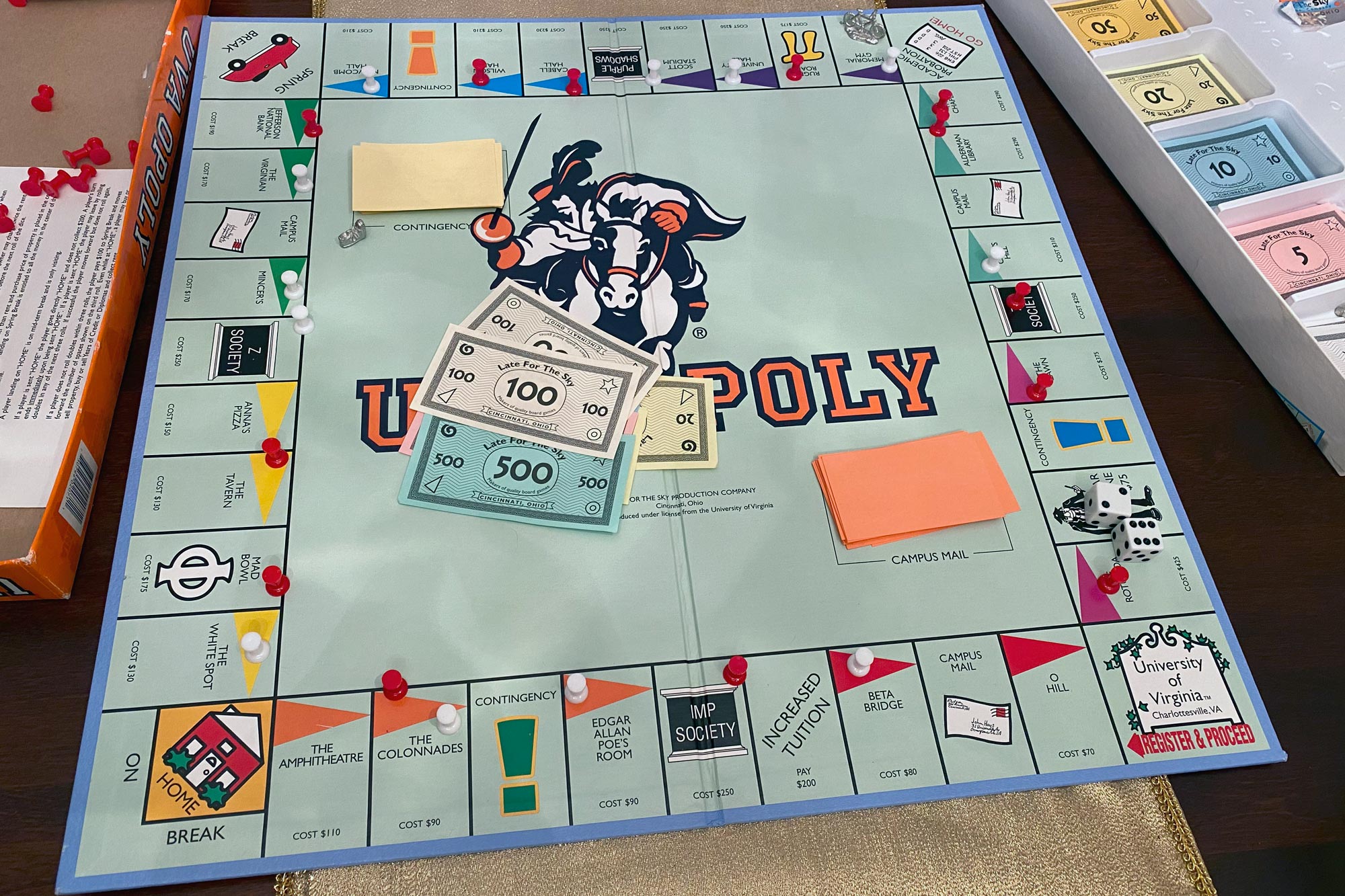 UVA themed Monopoly board with red and white pieces and money on the board