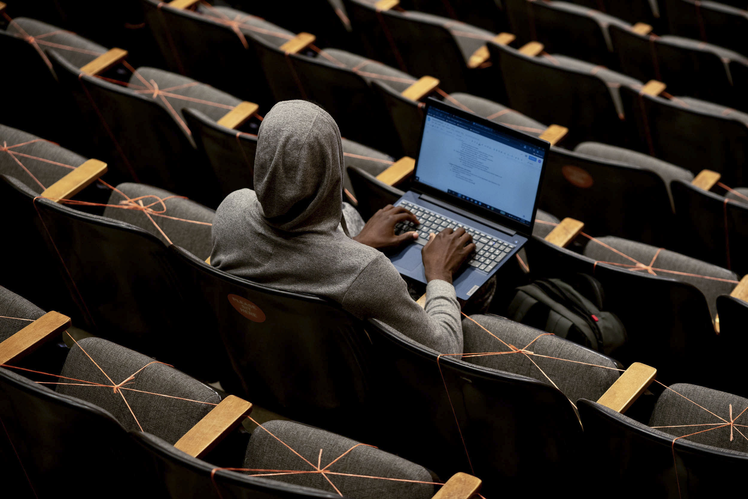 Student sitting in class with their laptop