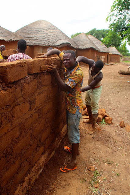 Villagers help construct a shed to house a new local solar power business that will rent out batteries and offer a place to charge cell phones.