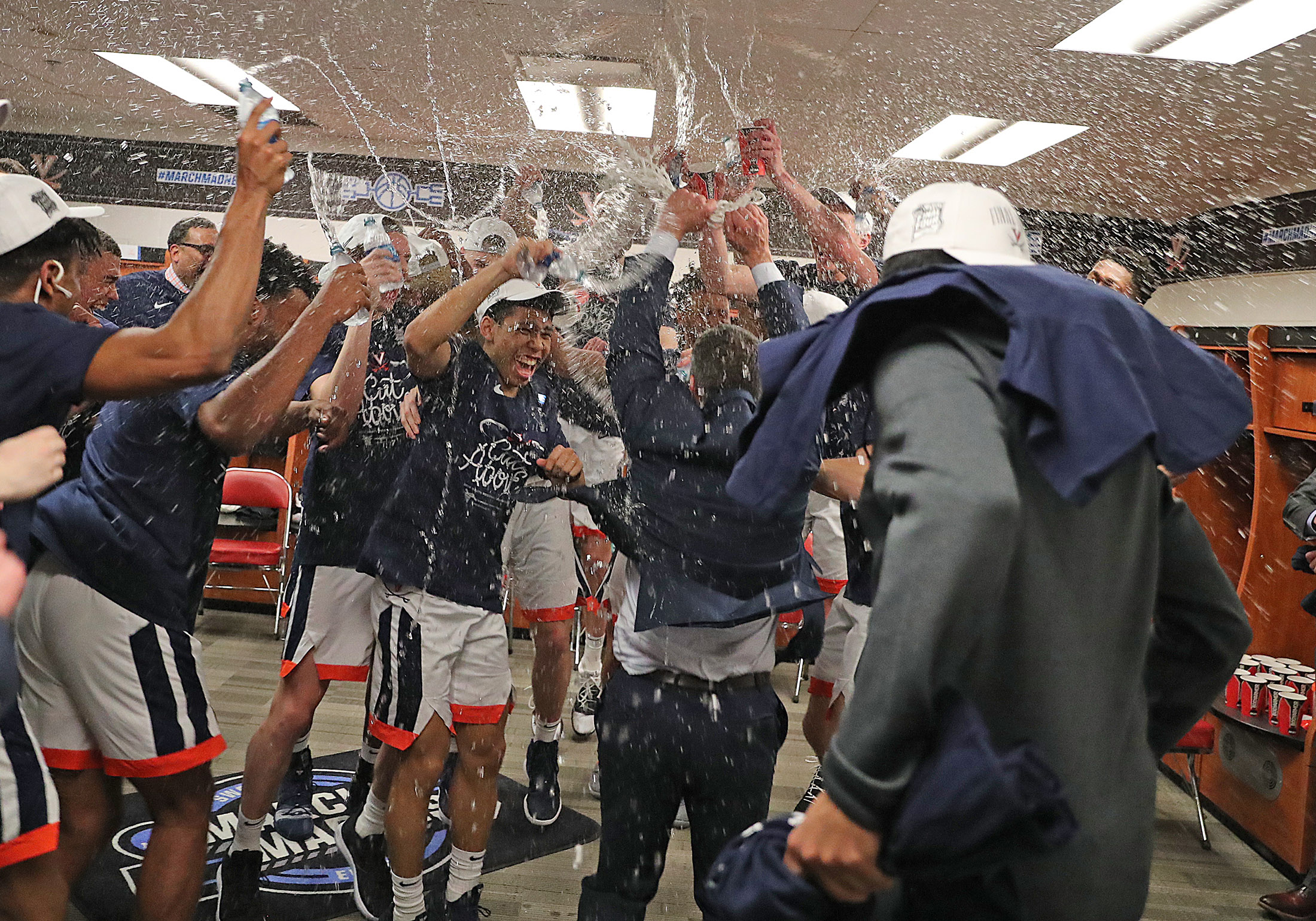 Water being thrown into the air of the locker room by the players and staff