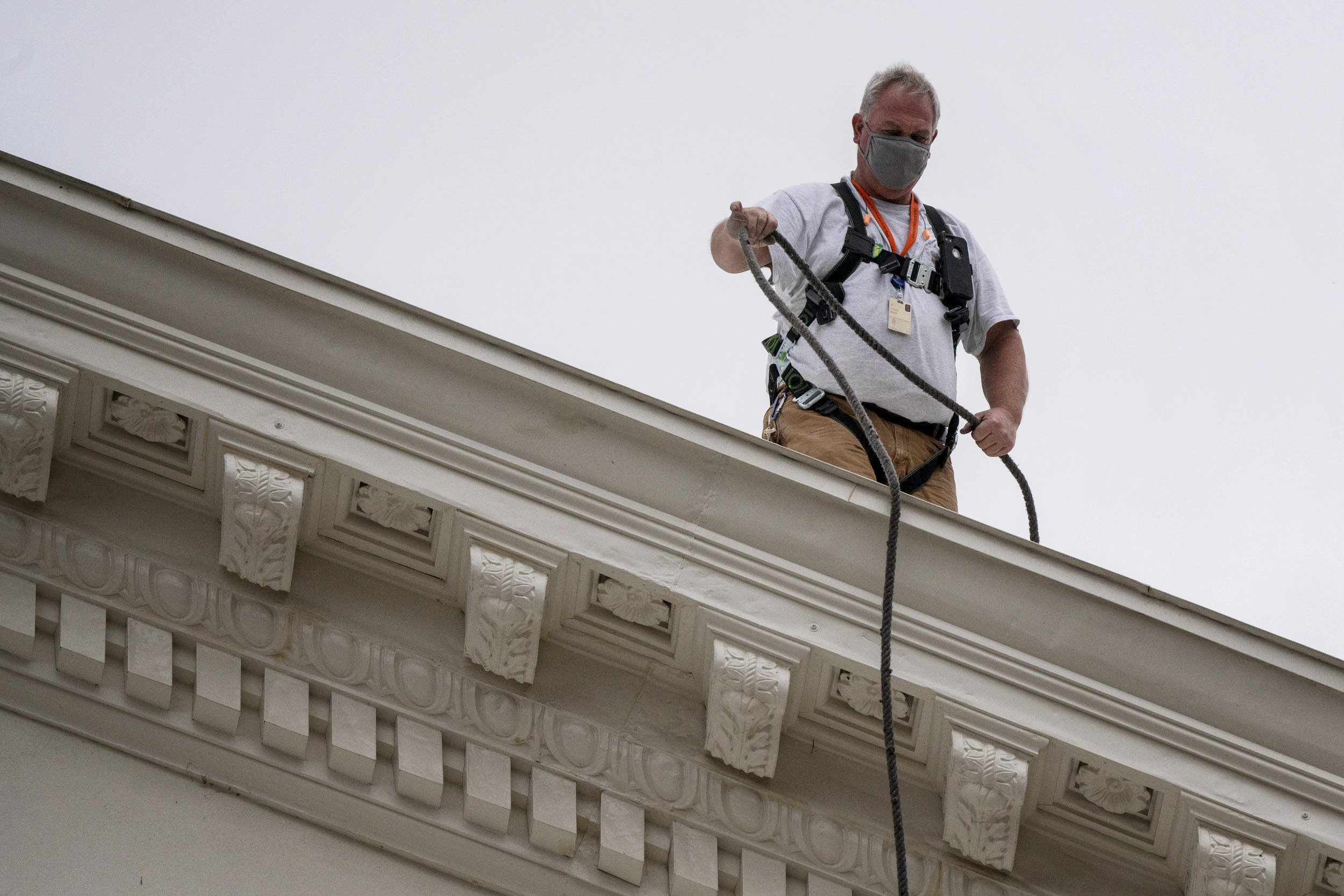 Man on top of the Rotunda with a hose