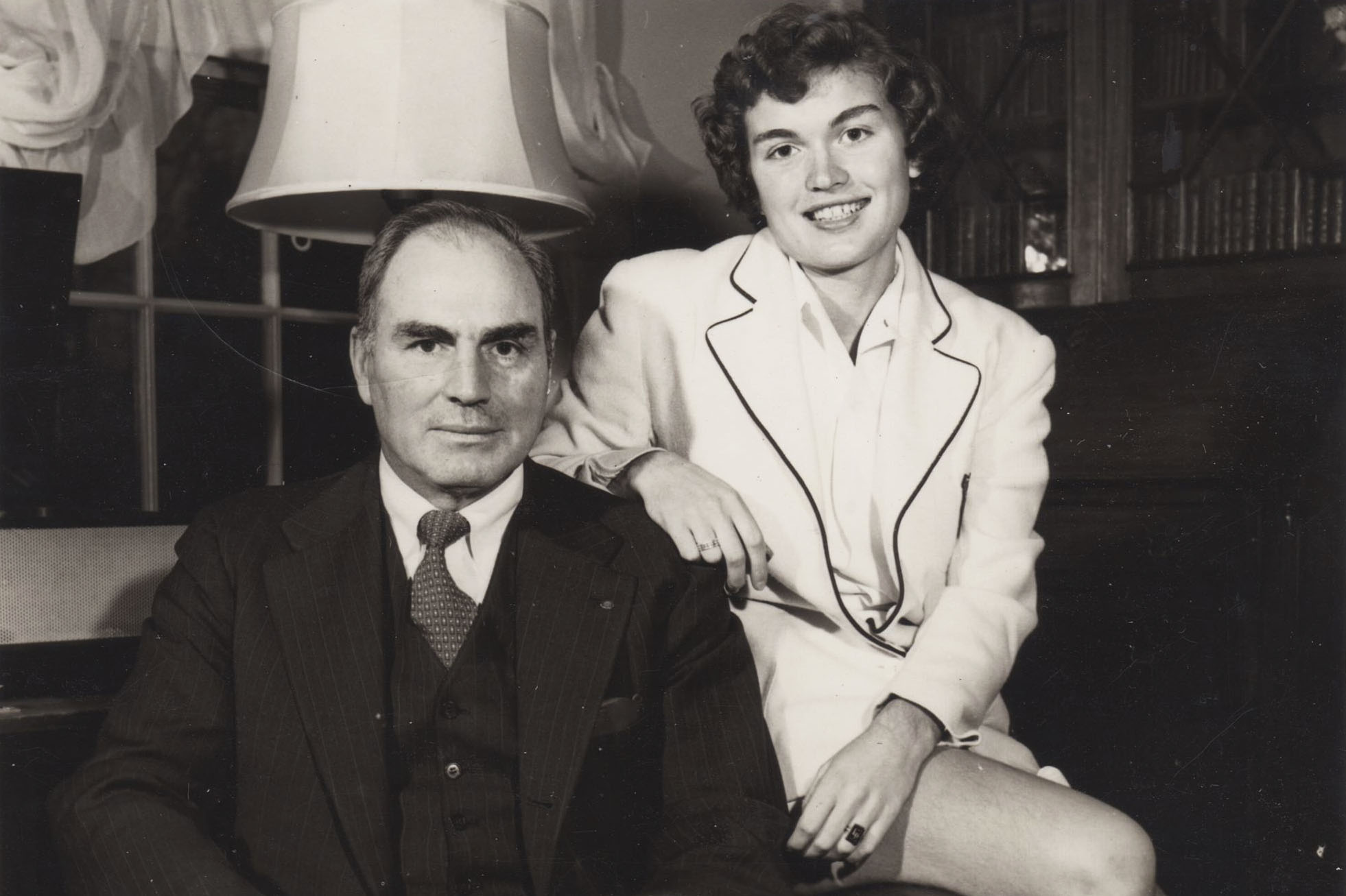 Black and white photo of Mary Slaughter and her father, Butch, sitting together on a chair looking at the camera