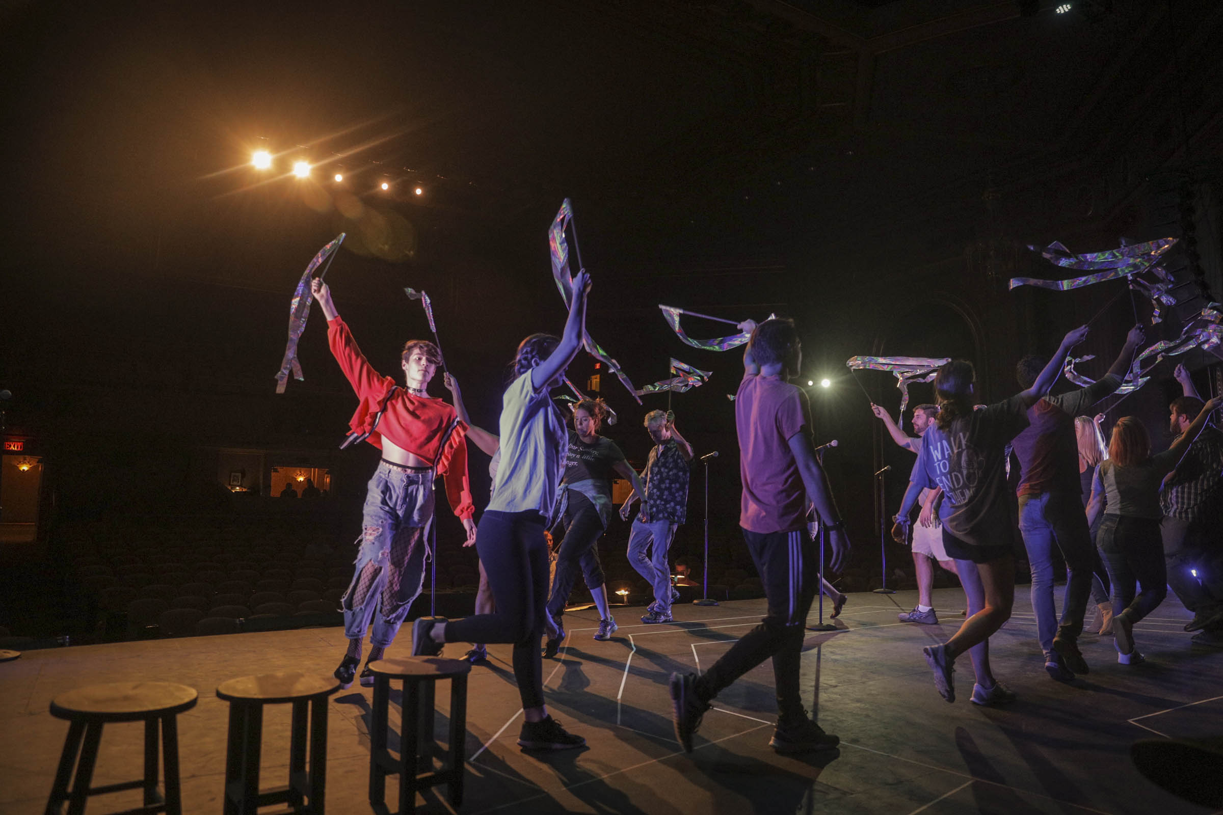 Theatre performers raising streamers into the air