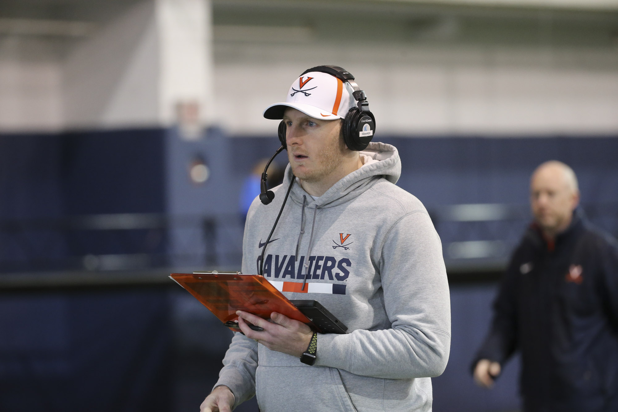 Matt Edwards holding a clipboard and watching a practice