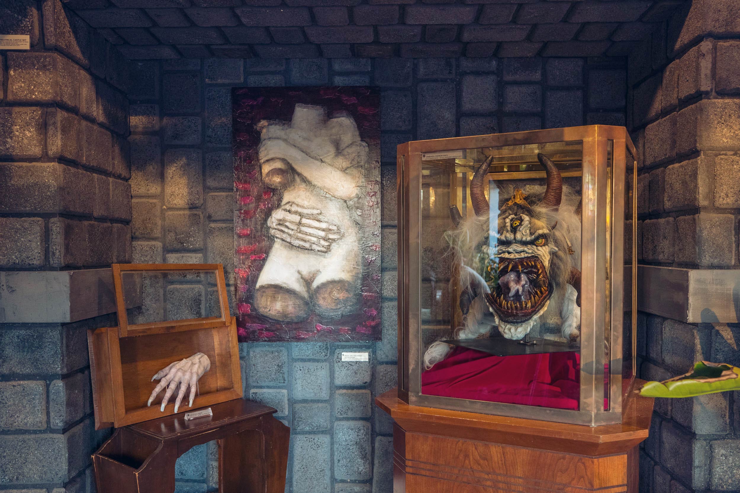 Horror-themed items on display in a room with fake stone walls