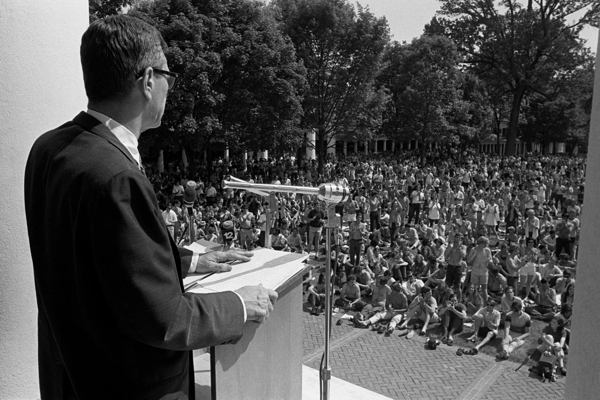 Black and white image of President Shannon speaking at a podium to a massive crowd on the Lawn