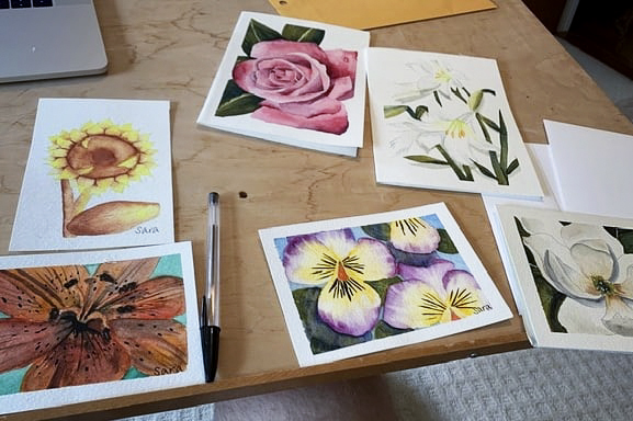 Cards laying on a table with a black pen