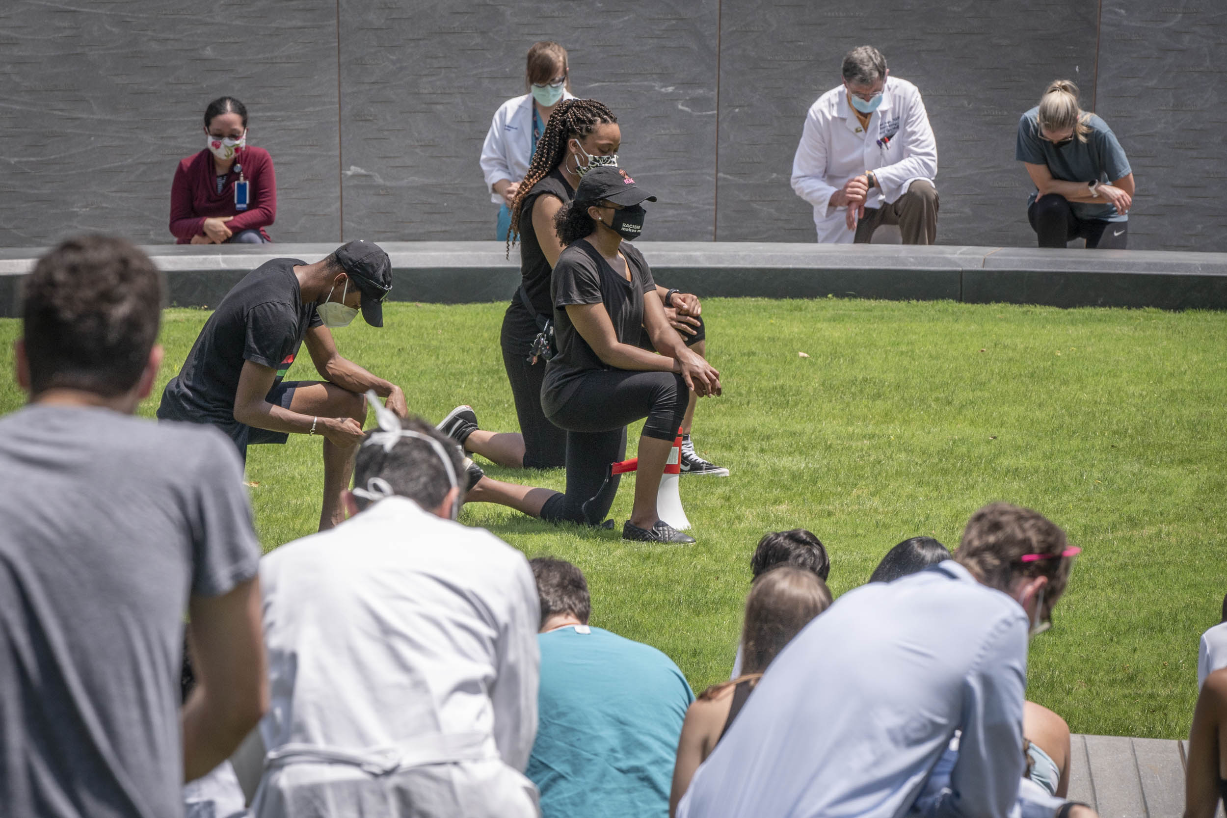 People gather at the Memorial of Enslaved Laborers and kneel