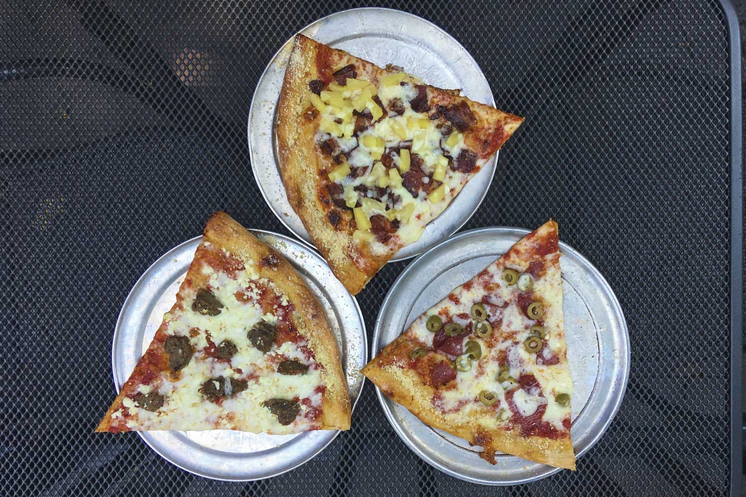 Various kinds of pizza on metal plates