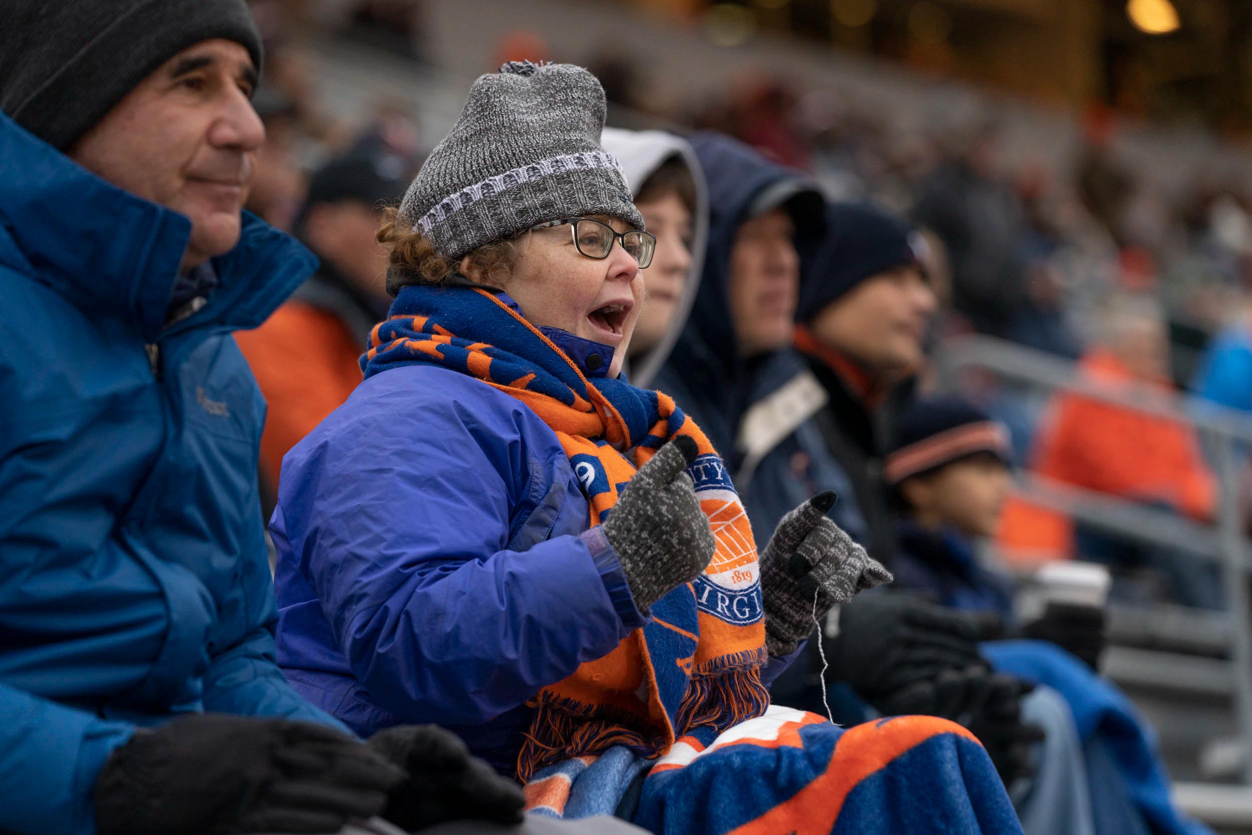 Fans bundled up in warm clothing as they cheer for the football team