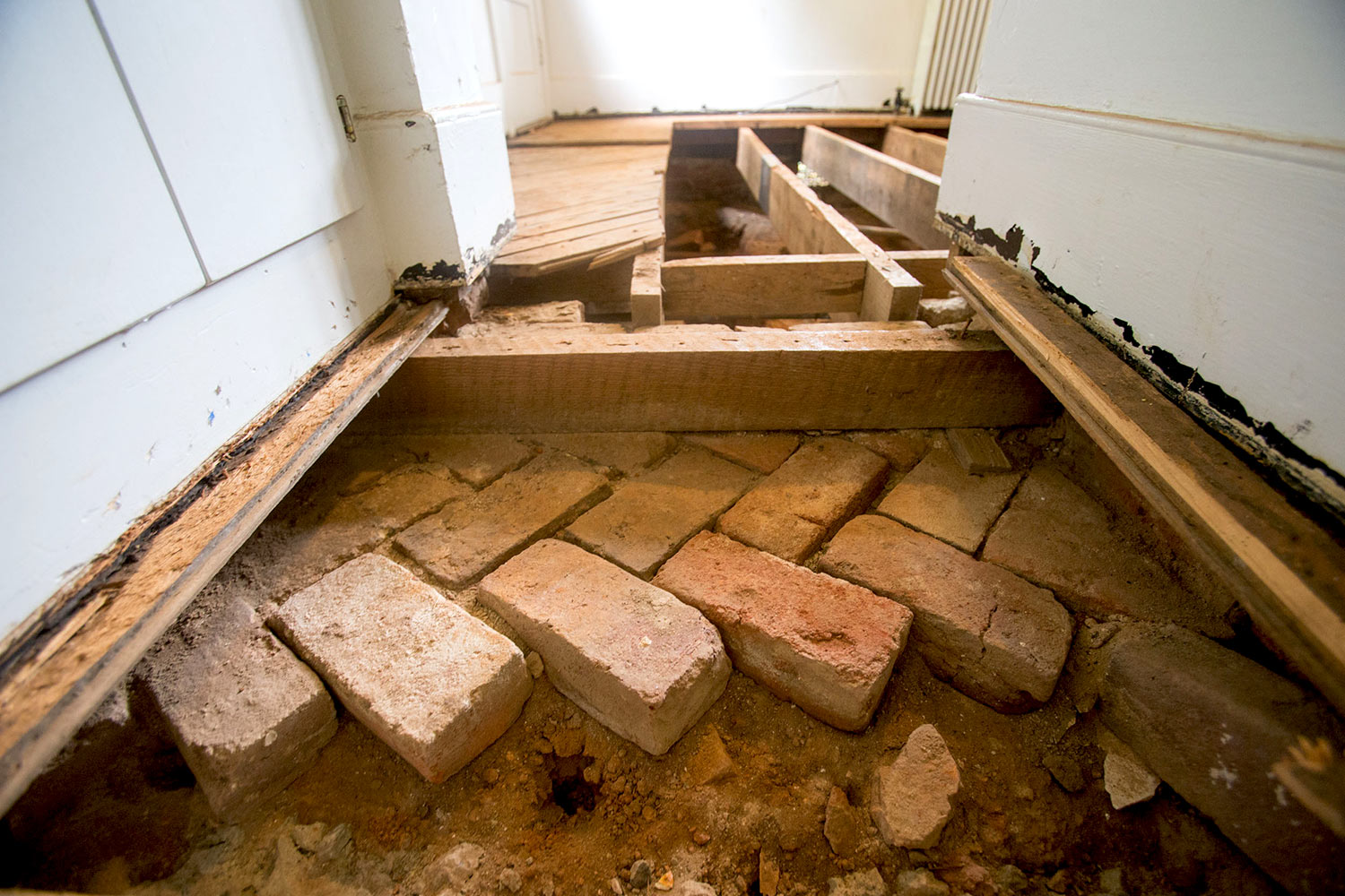 These bricks, laid in a herringbone pattern, are believed to be part of the original floor for the kitchen structure, which became the central room when The Mews was expanded.