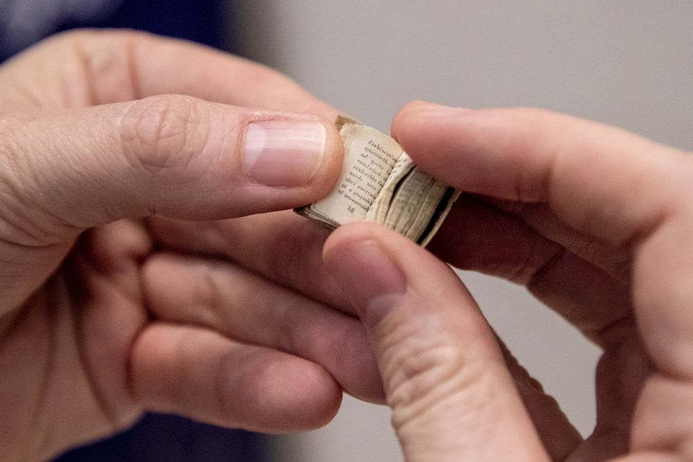 person flipping through the pages of an old mini book