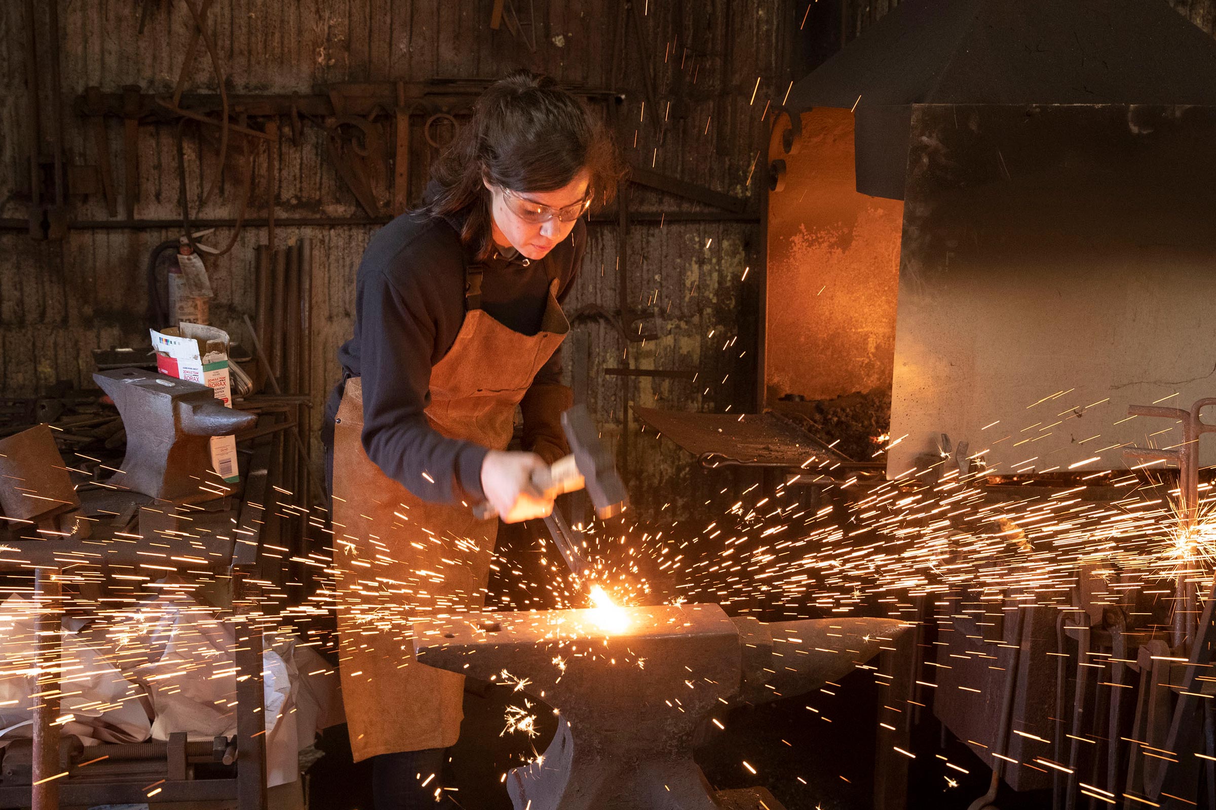 Mira du Plessis using a hammer to create something in the Blacksmith shop