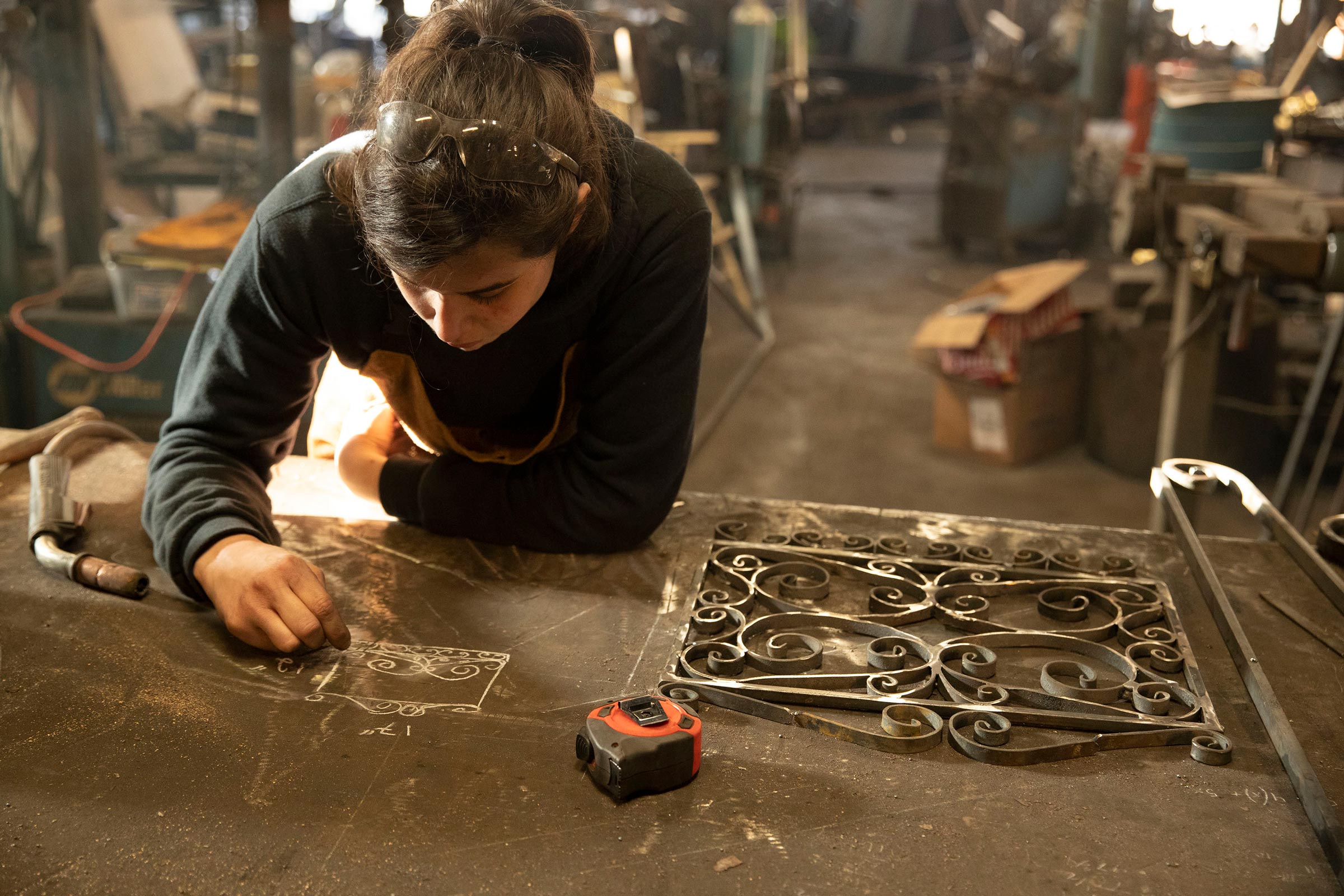 Mira du Plessis drawing a design on a metal bench