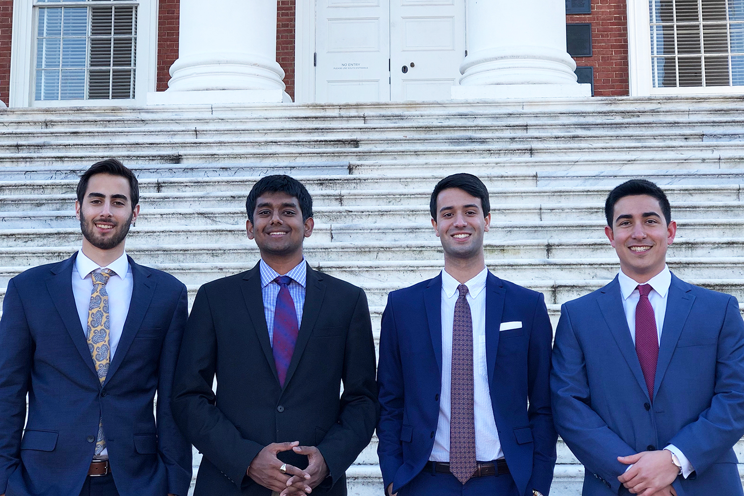 from left, Eric Taleghani, Rohit Rustagi, Alexander Singh and George Vithoulkas stand together for a group photo on the steps of the Rotunda