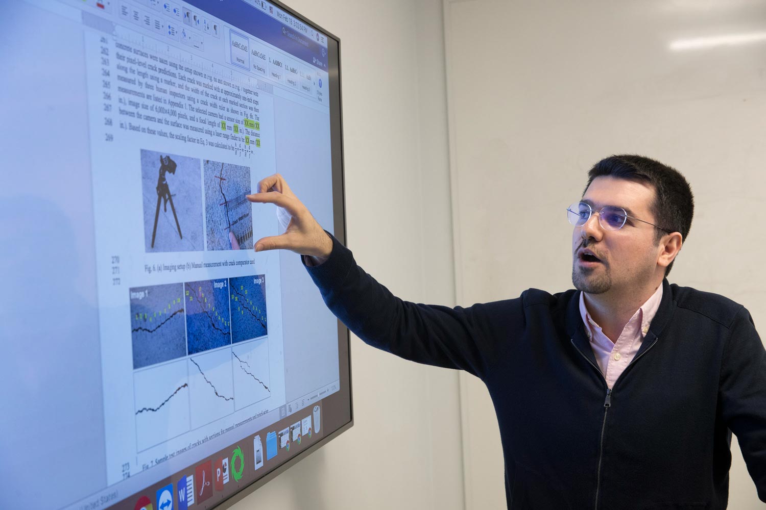 Mohamad Alipour points to a monitor while talking to a class