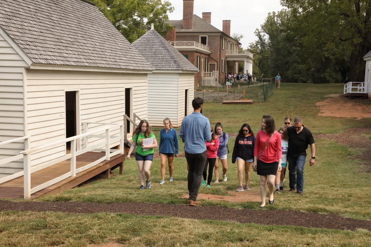 Christopher Pasch leads a group through a reconstructed slave quarters on Montpelier's South Lawn