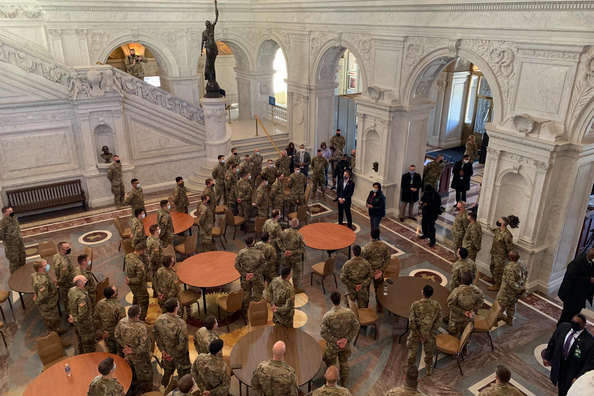 US service men and women standing in the hall of the capital as they listen directions