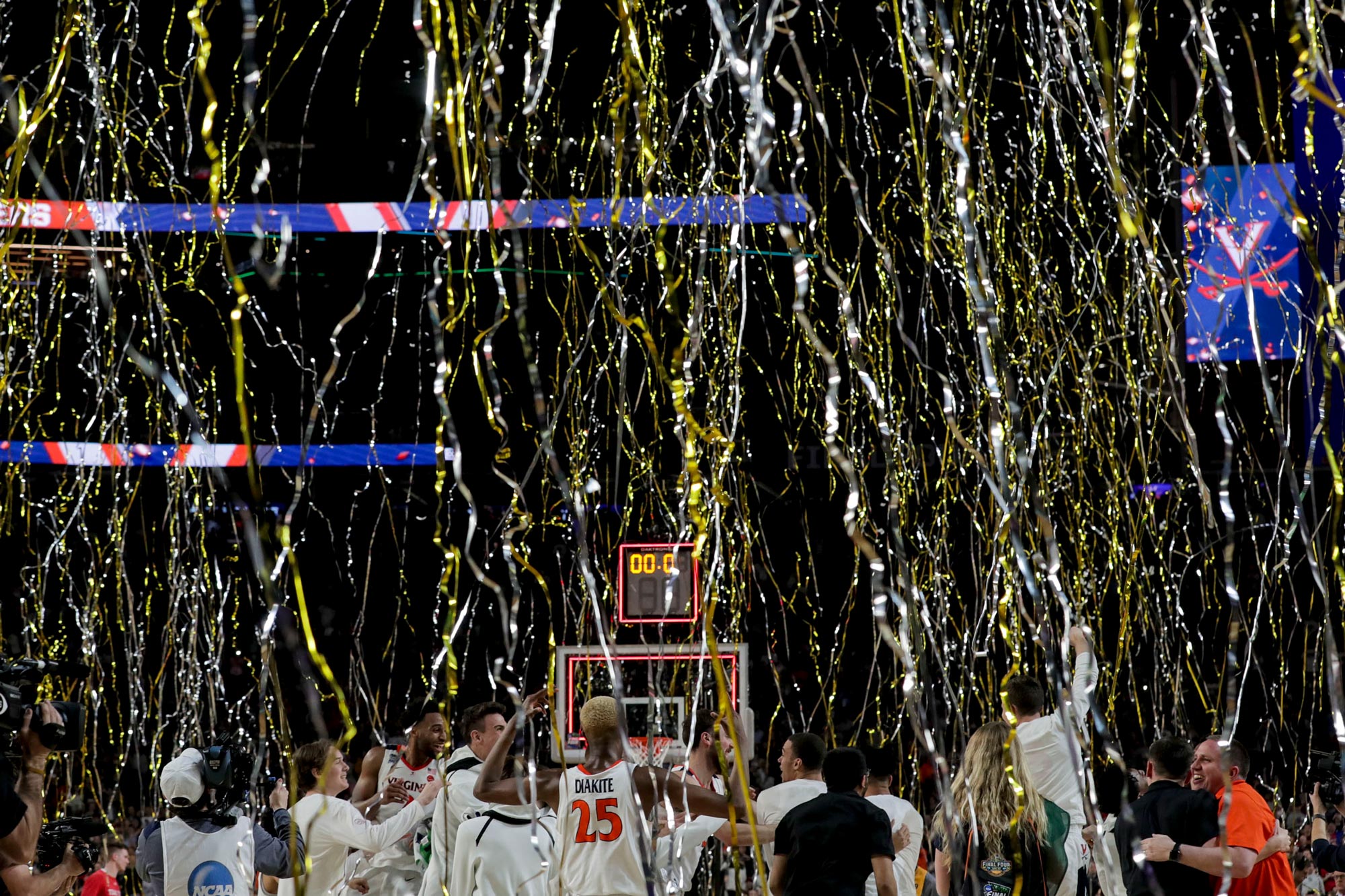 Gold and silver streamers falling from the sky as the UVA basketball team rushes the basketball court