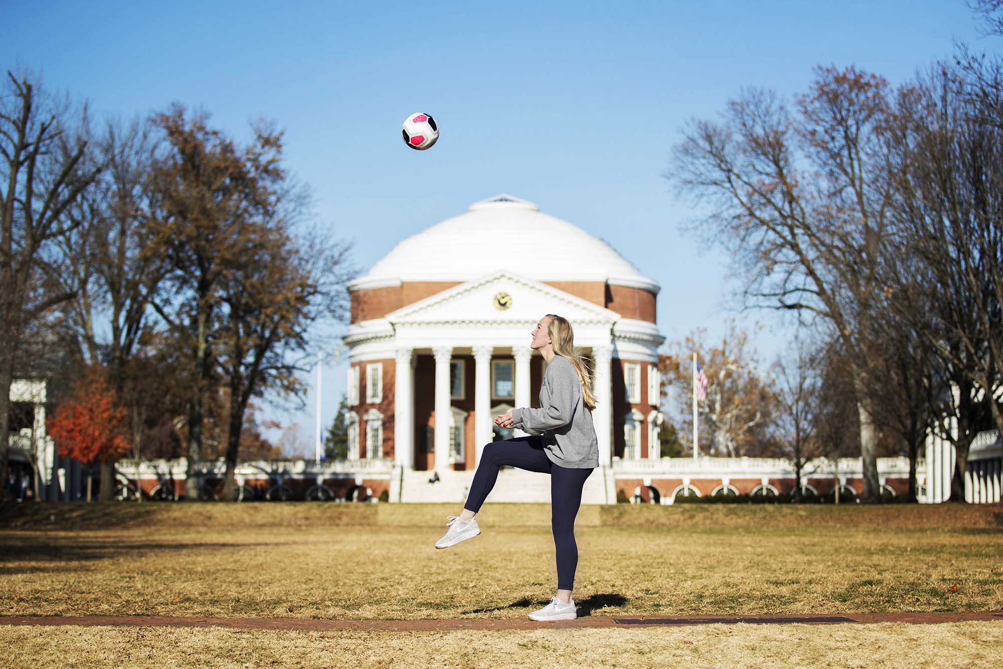 Morse kicking a soccer ball in the air in front of the Rotunda