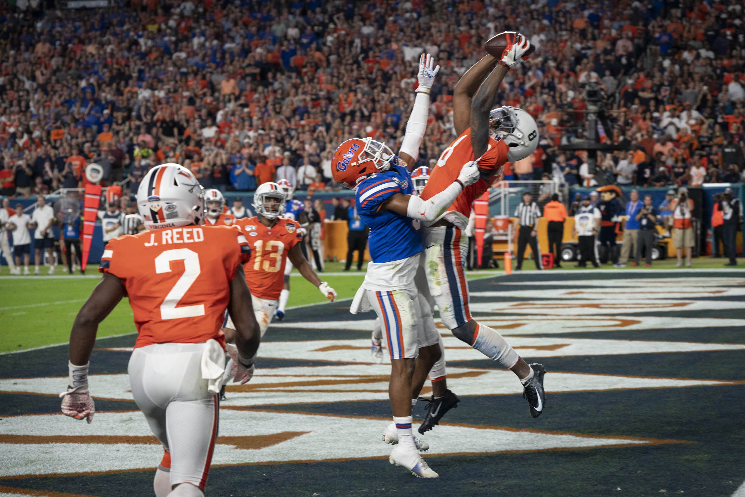 Hasise Dubois leaps to make a catch in the endzone with a Florida player grabbing him