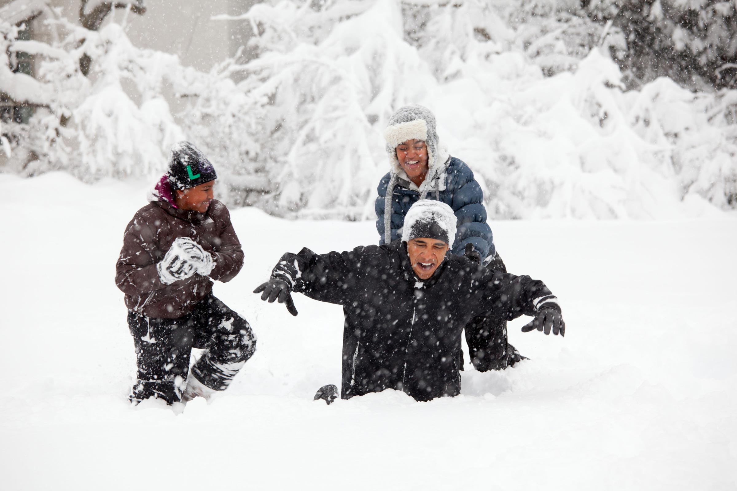 Obama playing in the snow with two other people