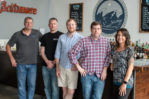 Mark McLaughlin, center, stands with the Old Line Spirits team for a group photo