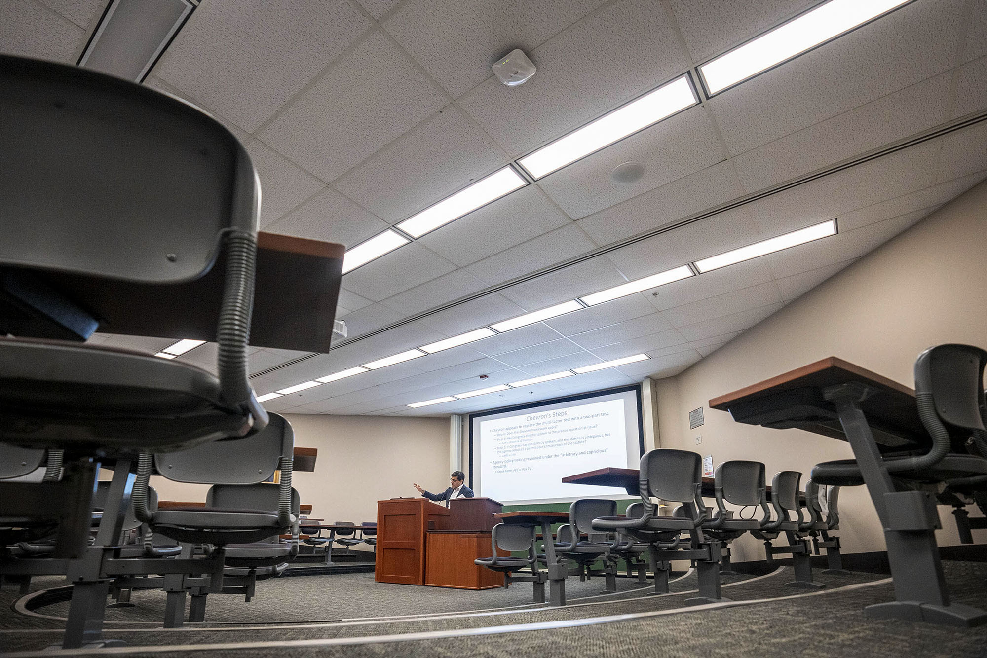 Profession standing at a podium for class with no students in person